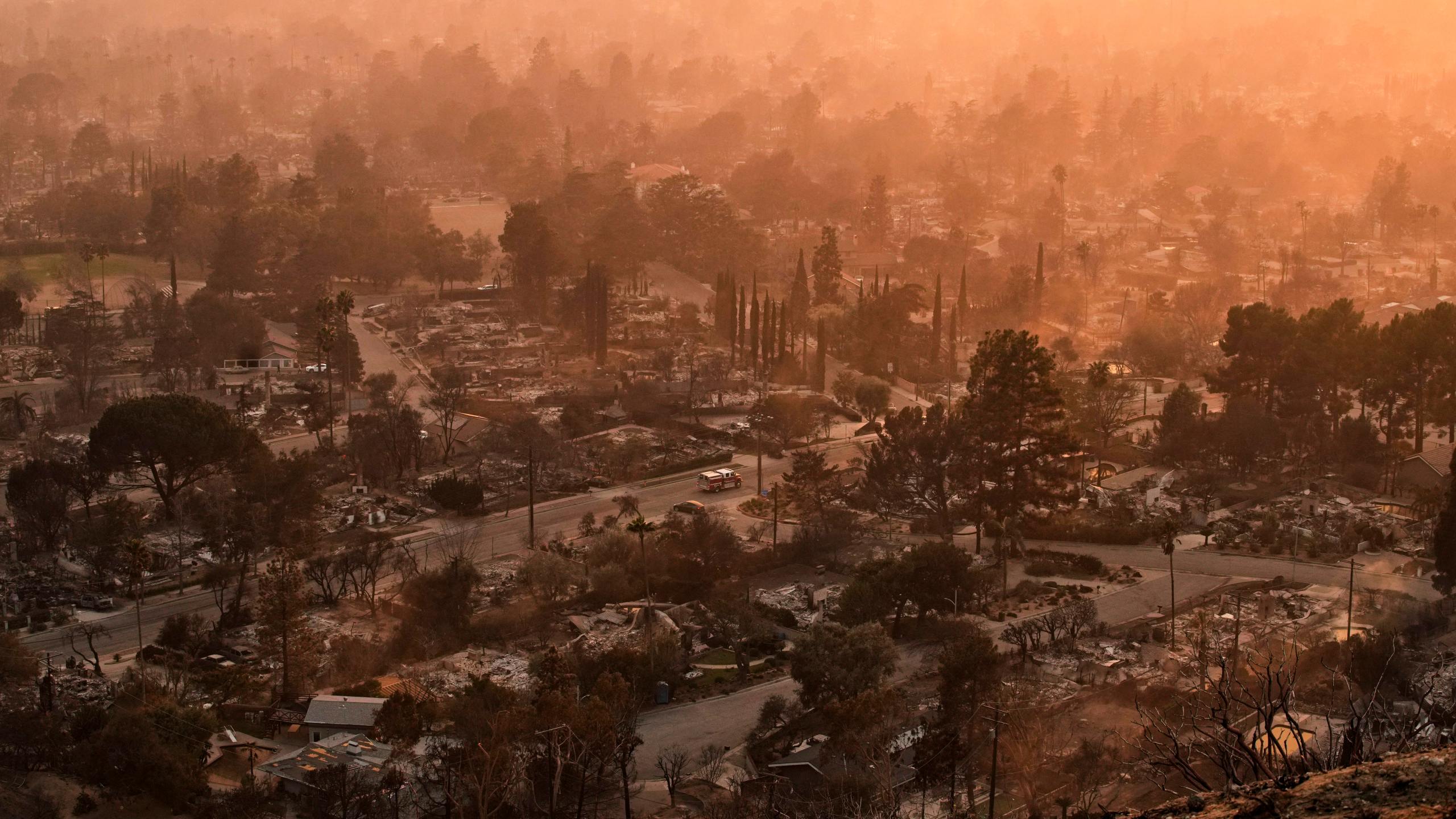 Smoke lingers over a neighborhood devastated by the Eaton Fire, Thursday, Jan. 9, 2025, in Altadena, Calif. (AP Photo/John Locher)