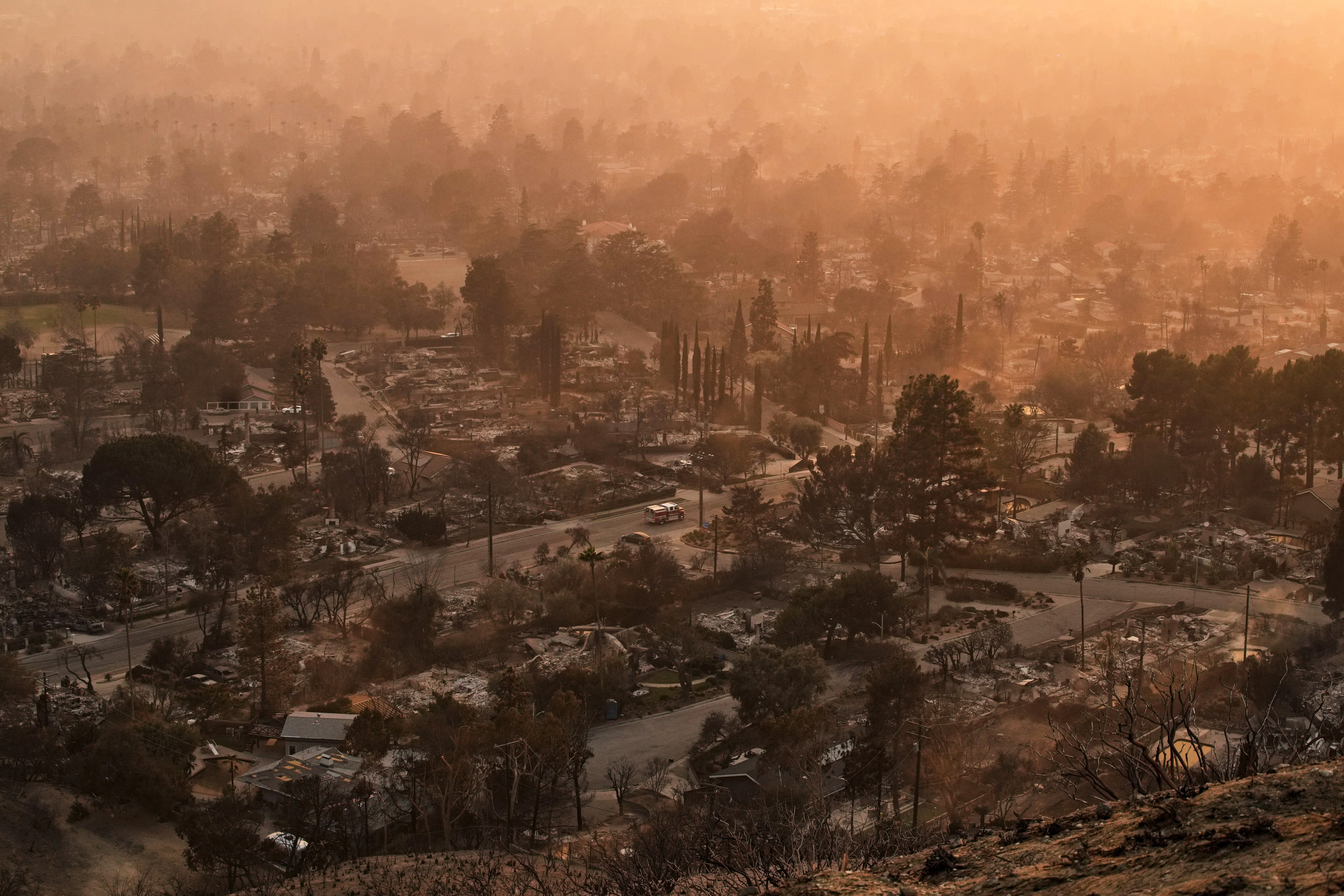 Smoke lingers over a neighborhood devastated by the Eaton Fire, Thursday, Jan. 9, 2025, in Altadena, Calif. (AP Photo/John Locher)