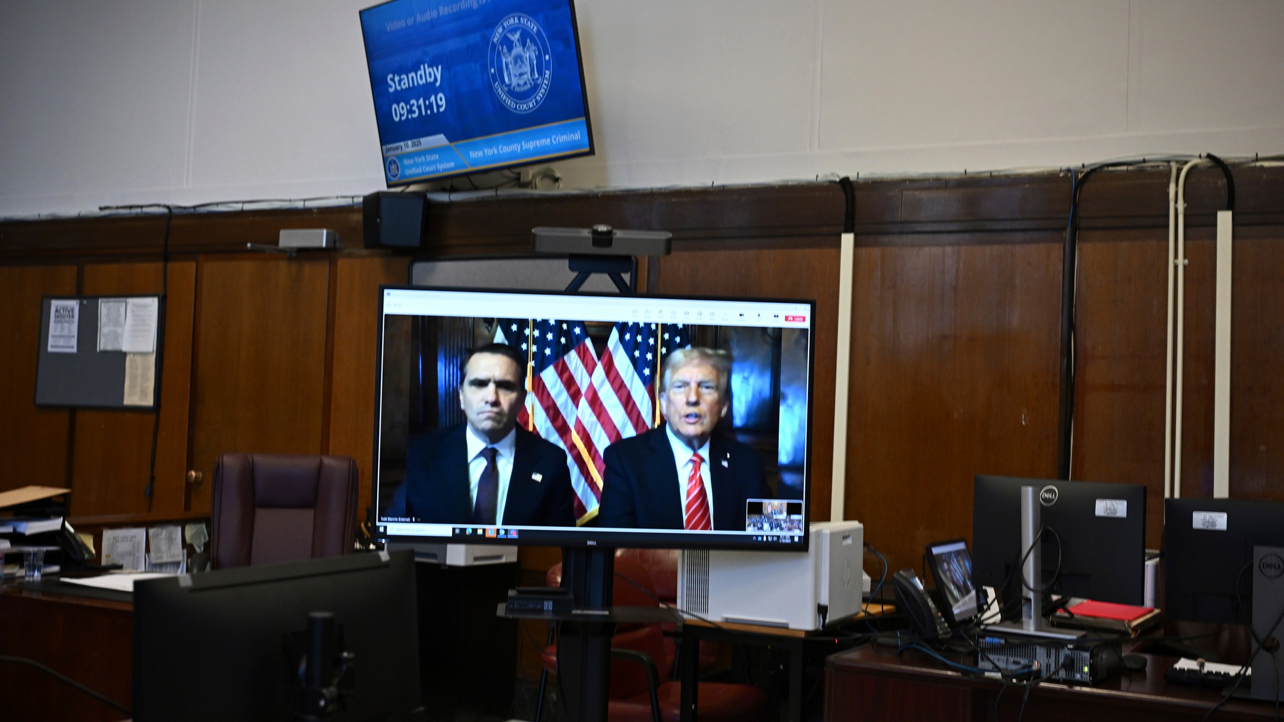 Attorney Emil Bove, left, listens as attorney Todd Blanche and President-elect Donald Trump, seen on a television screen, appear virtually for sentencing for Trump's hush money conviction in a Manhattan courtroom on Friday, Jan. 10, 2025 in New York. (Angela Weiss/Pool Photo via AP)