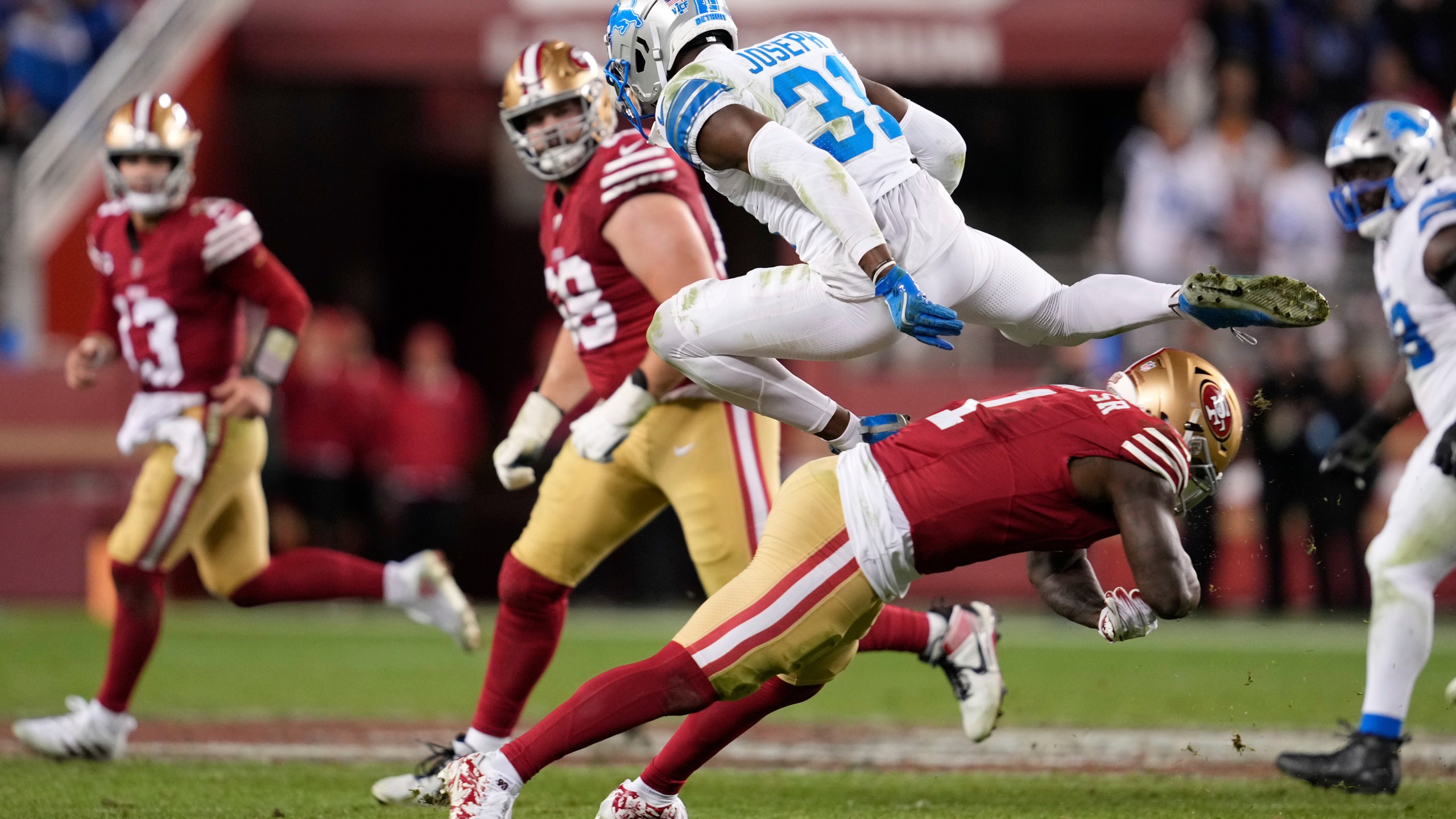 Detroit Lions safety Kerby Joseph (31) leaps over San Francisco 49ers wide receiver Deebo Samuel Sr. (1) after intercepting a pass during the second half of an NFL football game Monday, Dec. 30, 2024, in Santa Clara, Calif. (AP Photo/Godofredo A. Vásquez)