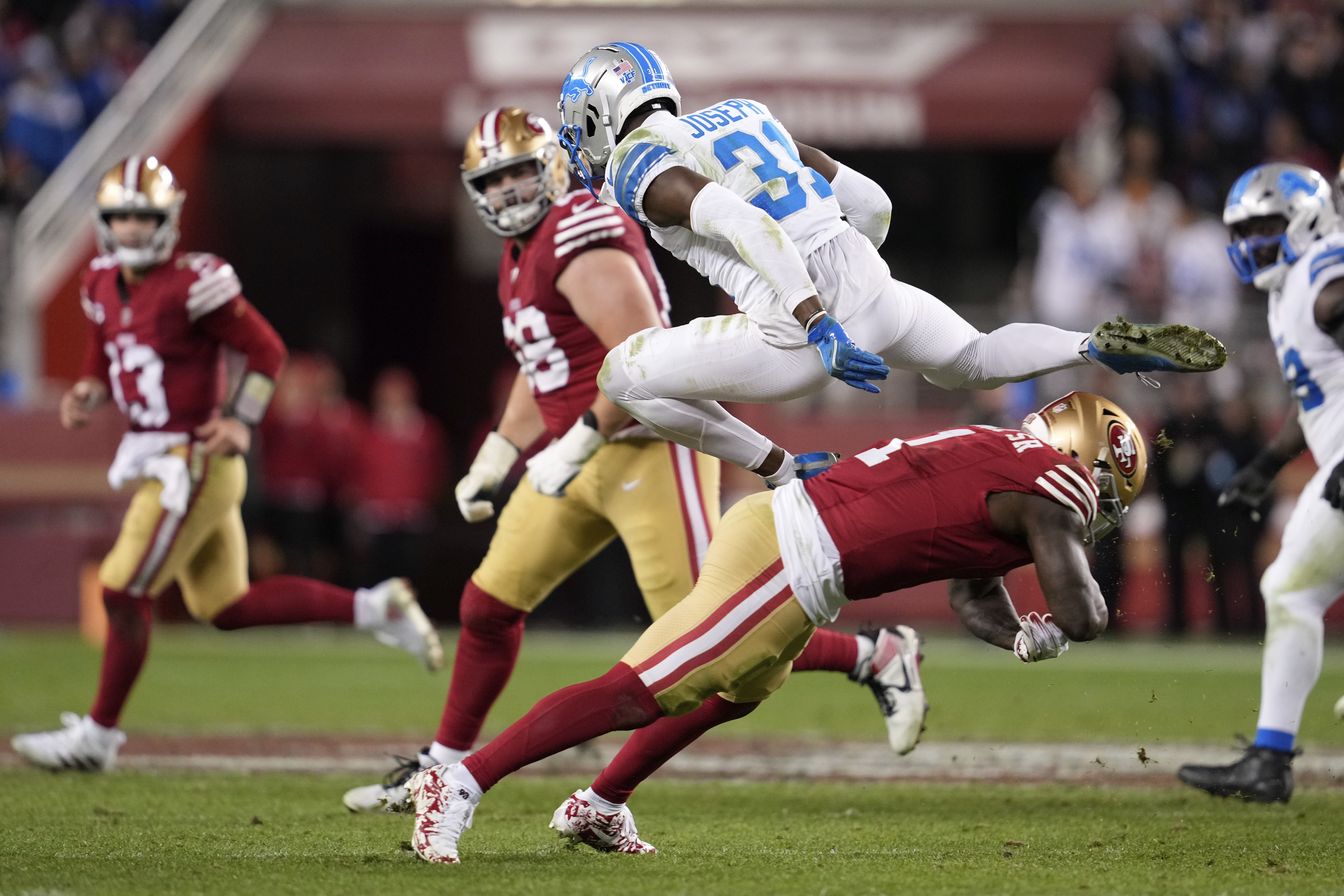 Detroit Lions safety Kerby Joseph (31) leaps over San Francisco 49ers wide receiver Deebo Samuel Sr. (1) after intercepting a pass during the second half of an NFL football game Monday, Dec. 30, 2024, in Santa Clara, Calif. (AP Photo/Godofredo A. Vásquez)