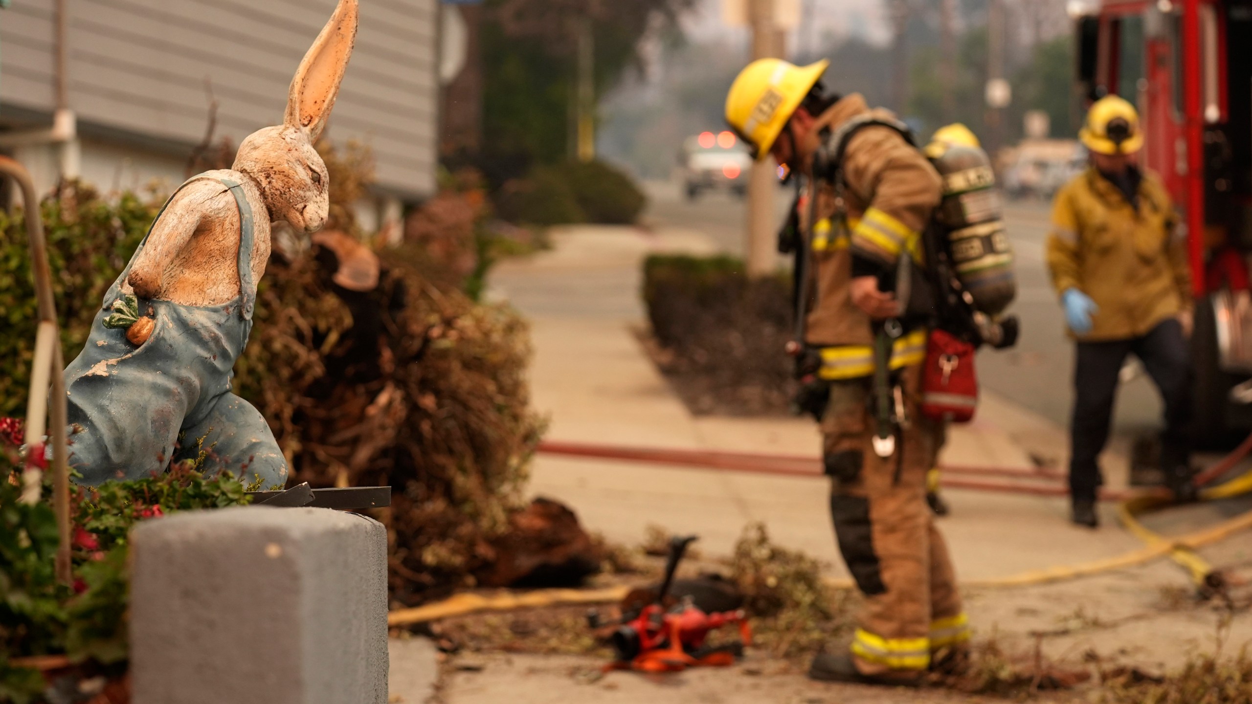 A firefighter looks at charred remains outside the destroyed Bunny Museum, Thursday, Jan. 9, 2025, in the Altadena section of Pasadena, Calif. (AP Photo/Chris Pizzello)