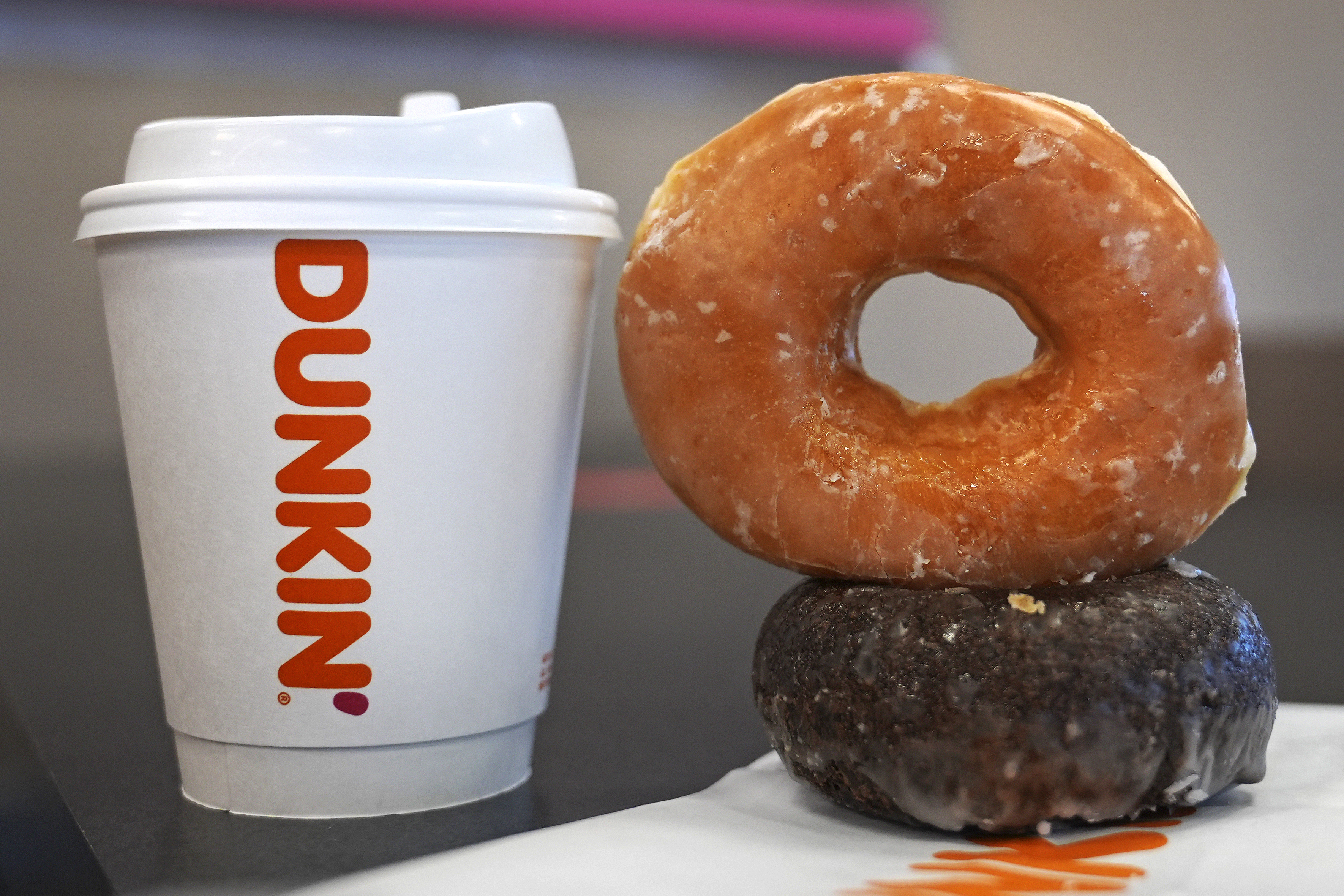 Two donuts and a cup of coffee rest on a counter at a Dunkin' location, Friday, Jan. 10, 2025, in Derry, N.H. (AP Photo/Charles Krupa)