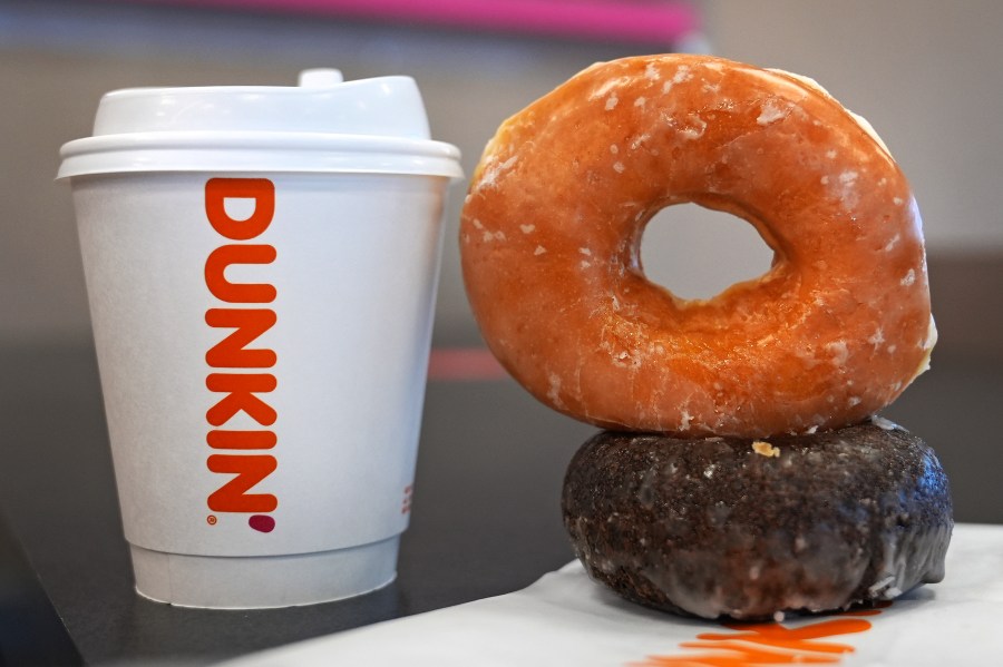 Two donuts and a cup of coffee rest on a counter at a Dunkin' location, Friday, Jan. 10, 2025, in Derry, N.H. (AP Photo/Charles Krupa)