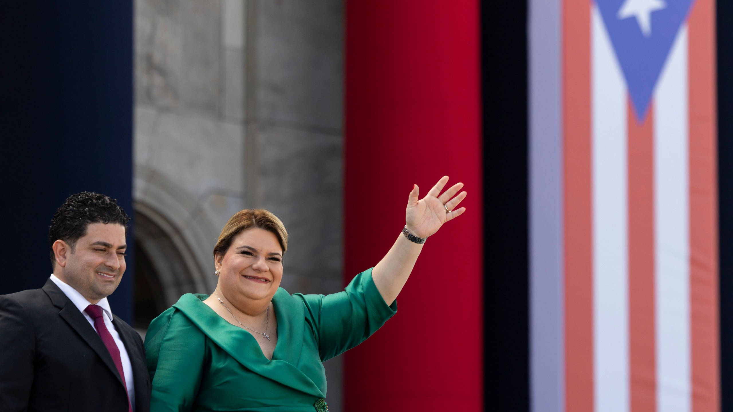 Jenniffer Gonzalez Colon waves alongside her husband Jose Yovin Vargas during her swearing-in ceremony as governor outside the Capitol in San Juan, Puerto Rico, Thursday, Jan. 2, 2025. (AP Photo/Alejandro Granadillo)