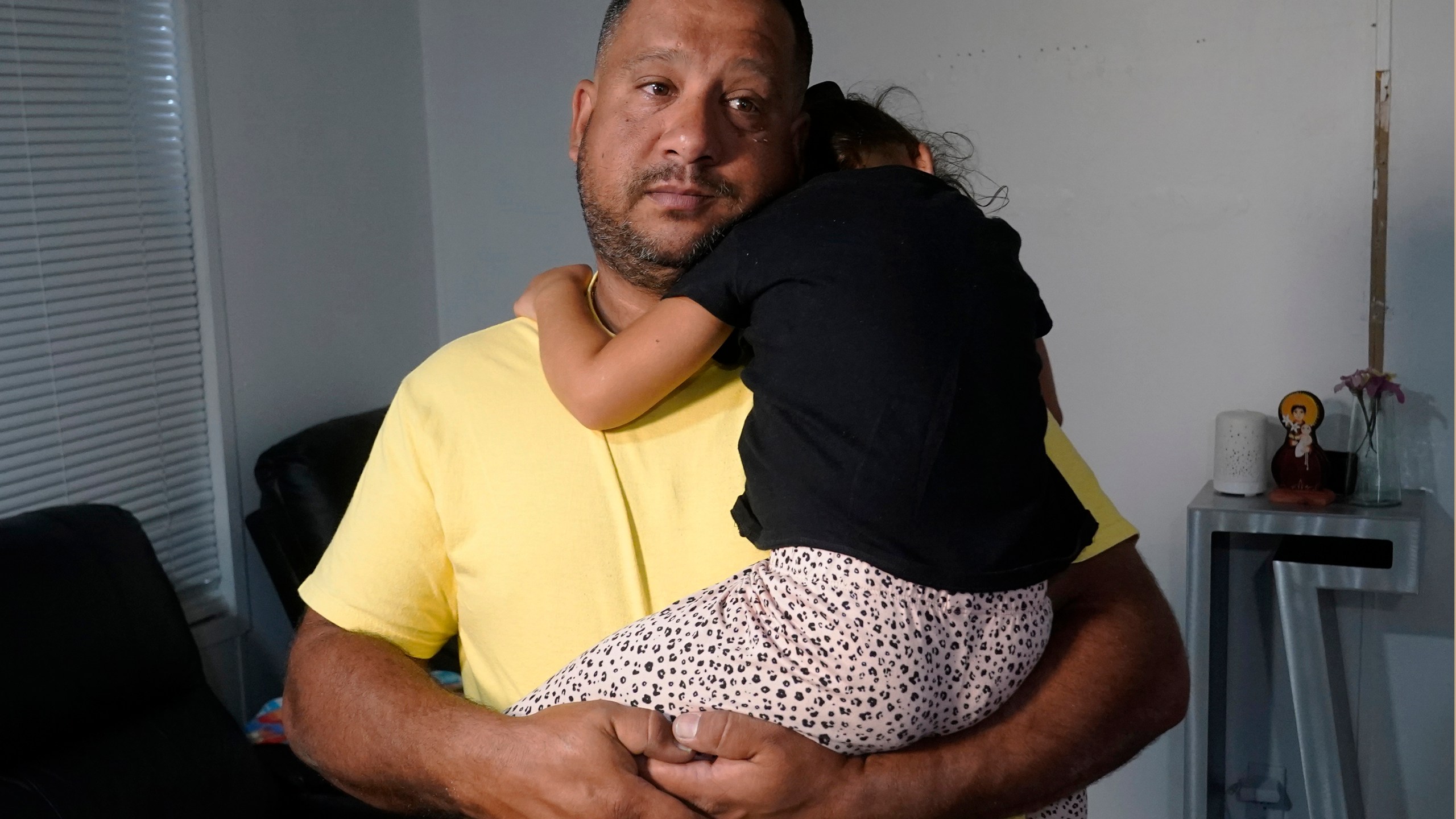 FILE - Venezuelan Victor Macedo holds his daughter Sonia at their home, in in Davie, Fla., Sept. 27, 2023. The family crossed the border U.S. almost two years ago. Since then, they have been living in South Florida with the support of family and friends. They recently qualified for temporary protected status. (AP Photo/Marta Lavandier, File)