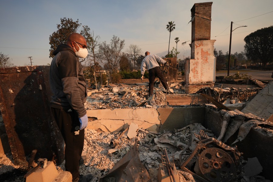 Kenneth Snowden, left, surveys the damage to his fire-ravaged property with his brother Ronnie in the aftermath of the Eaton Fire Friday, Jan. 10, 2025 in Altadena, Calif. (AP Photo/Jae C. Hong)