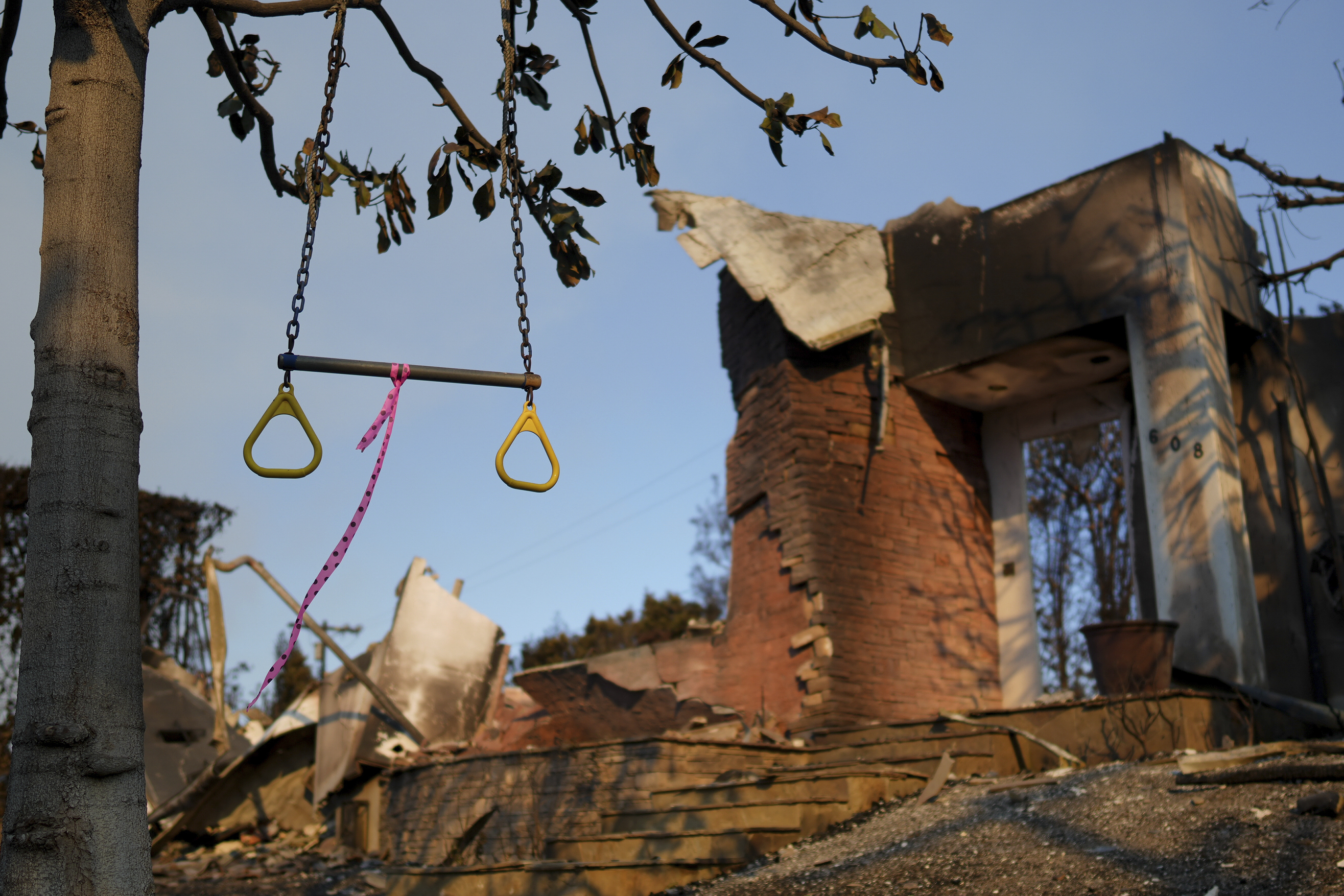 A swing hangs from a tree in front of a fire-damaged residence in the aftermath of the Palisades Fire in the Pacific Palisades neighborhood of Los Angeles, Friday, Jan. 10, 2025. (AP Photo/Eric Thayer)