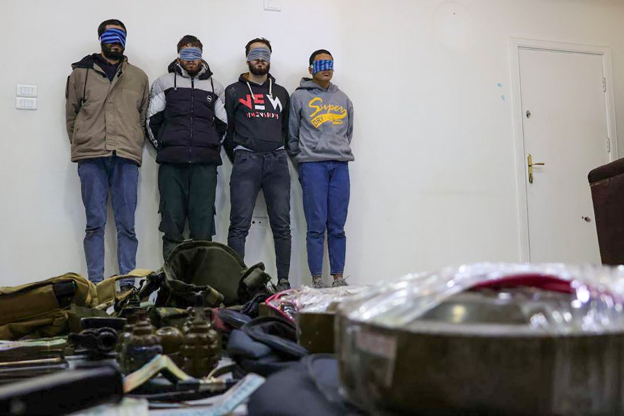 In this photo released by Syrian State TV, four suspects arrested in connection with an alleged plot by ISIS are shown standing against a wall in Damascus, Syria, Saturday, Jan. 11, 2025. Syrian intelligence officials, operating under the country's new de facto government, thwarted an attempt by ISIS to detonate a bomb at the Shiite shrine of Sayyida Zaynab in the Damascus suburb, according to state media reports on Saturday.(Syrian State TV via AP)