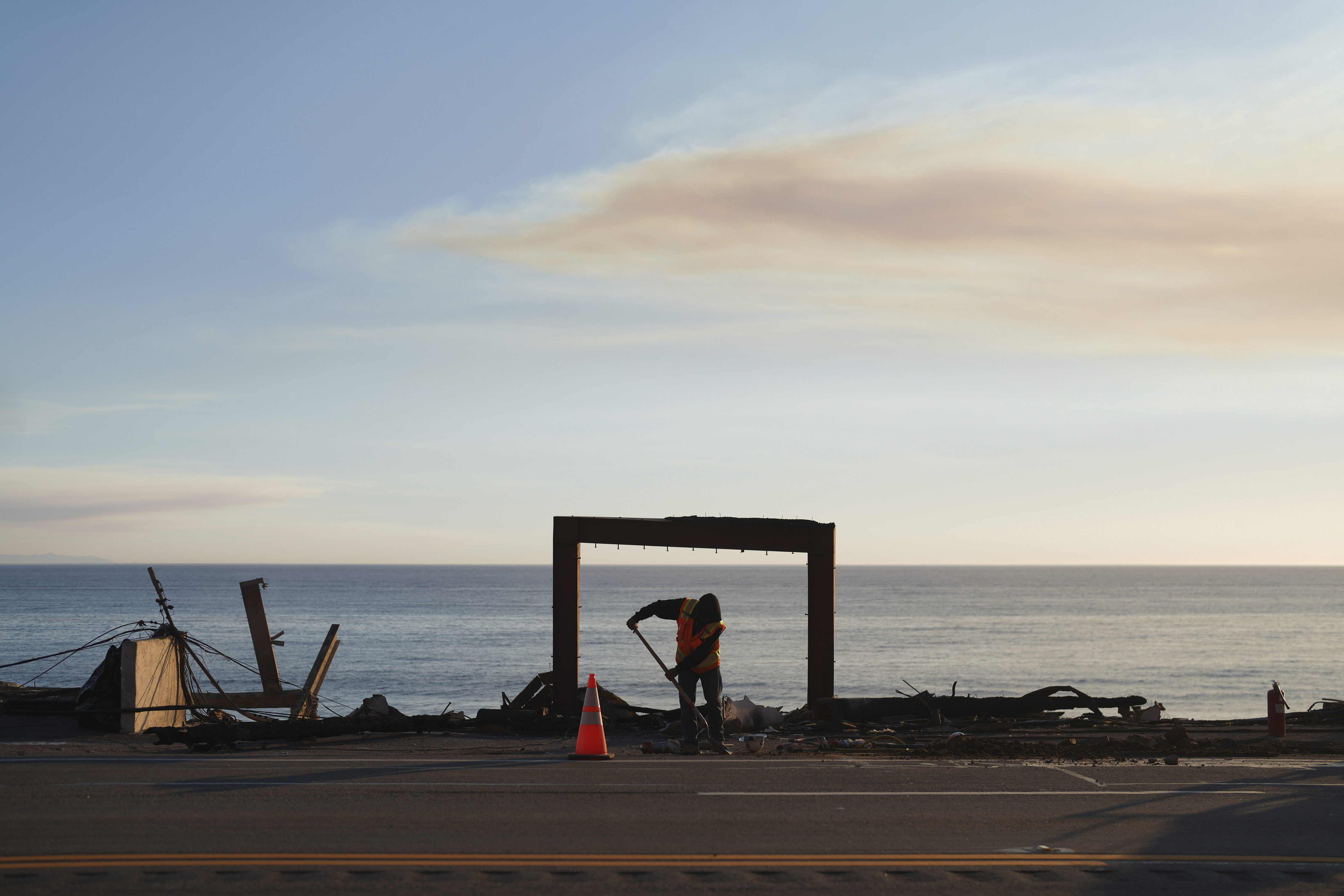 A worker clears debris from the Palisades Fire on Friday, Jan. 10, 2025, in Malibu, Calif. (AP Photo/Eric Thayer)