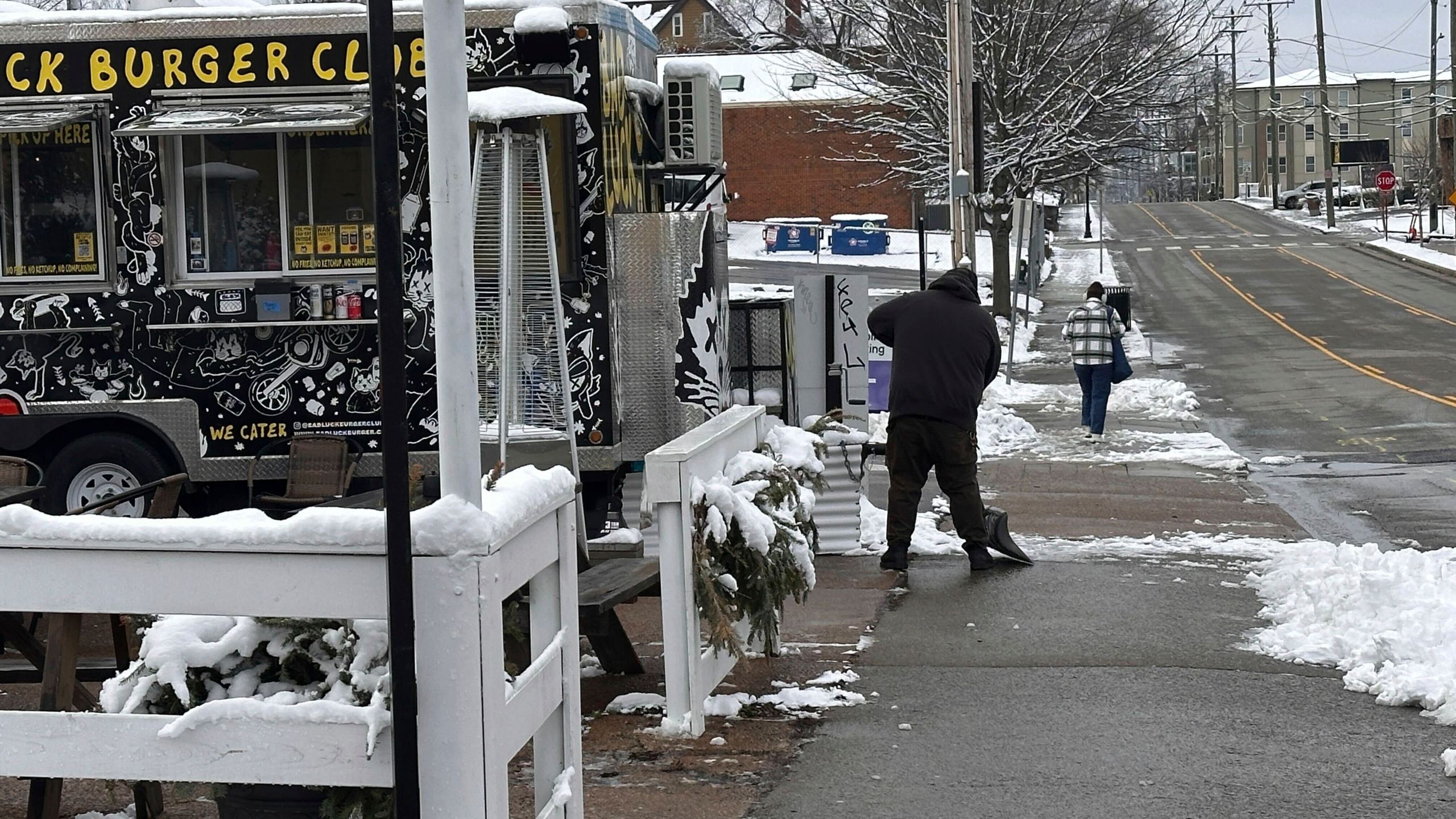 Andy Atkins removes snow from the outdoor seating area for his food truck Bad Luck Burger Club in Nashville, Tenn. on Saturday, Jan.11, 2025. (AP Photo/Kristin M. Hall)