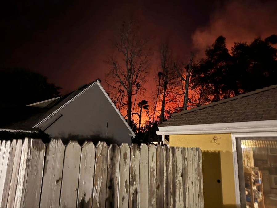 The Eaton wildfire approaches the yellow home of the Prata family in Altadena, California, the night of Tuesday, Jan. 7, 2025. (AP Photo/Vanessa Prata)