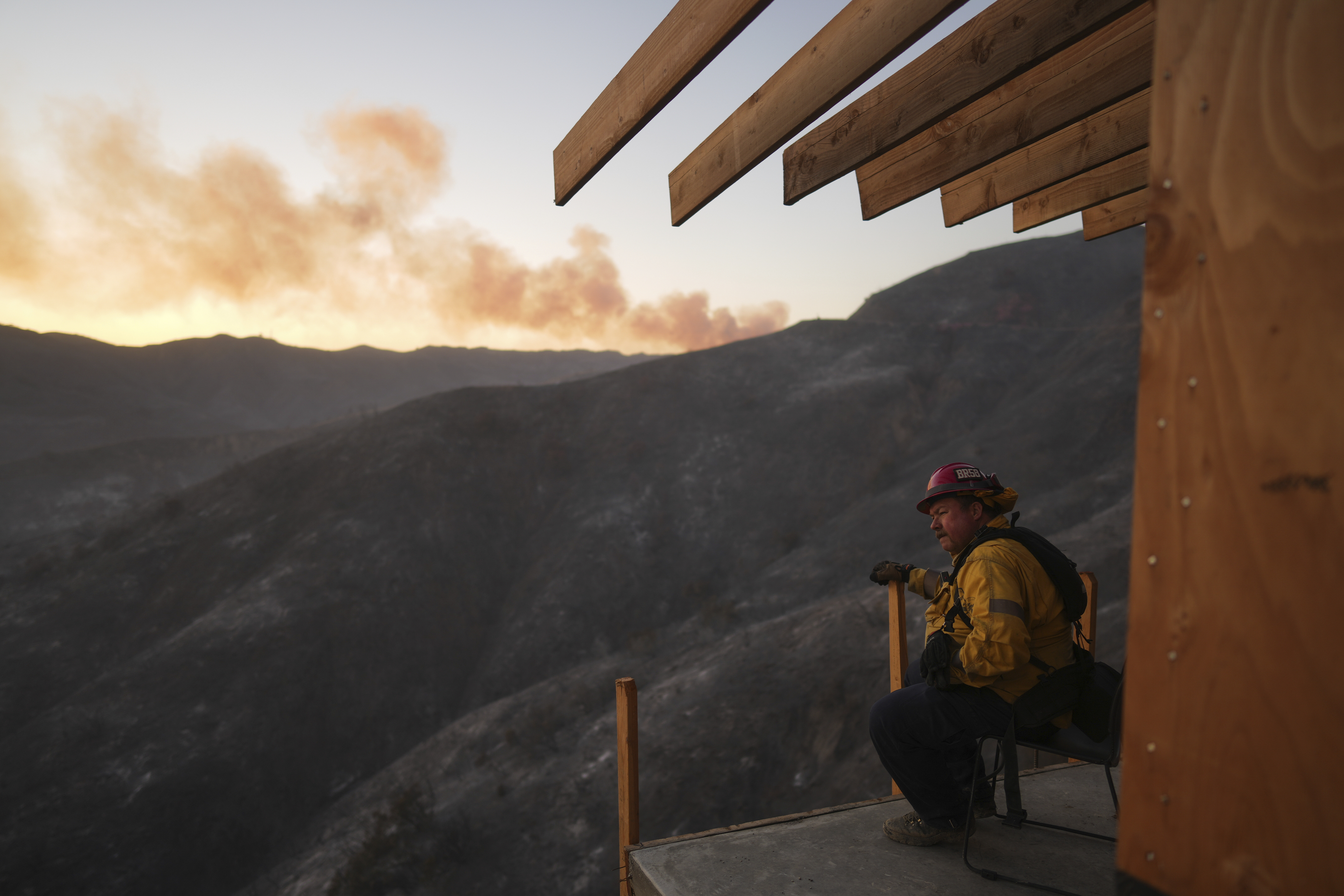 A firefighter rests as crews battle the Palisades Fire in Mandeville Canyon, Saturday, Jan. 11, 2025, in Los Angeles. (AP Photo/Eric Thayer)