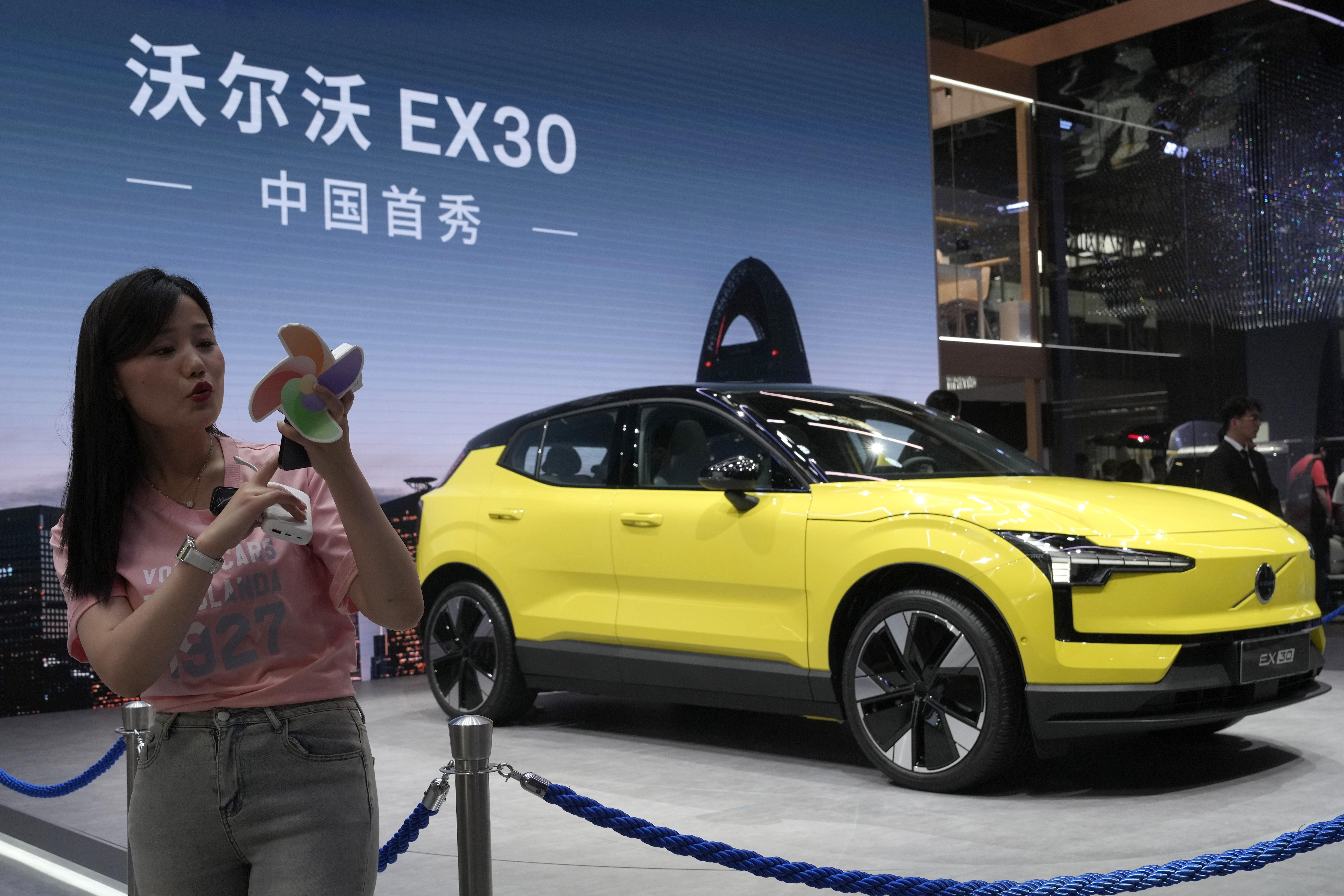 FILE - A live streamer works near the Volvo EX30 fully electric small SUV unveiled during Auto China 2024 in Beijing, Thursday, April 25, 2024. (AP Photo/Ng Han Guan, File)