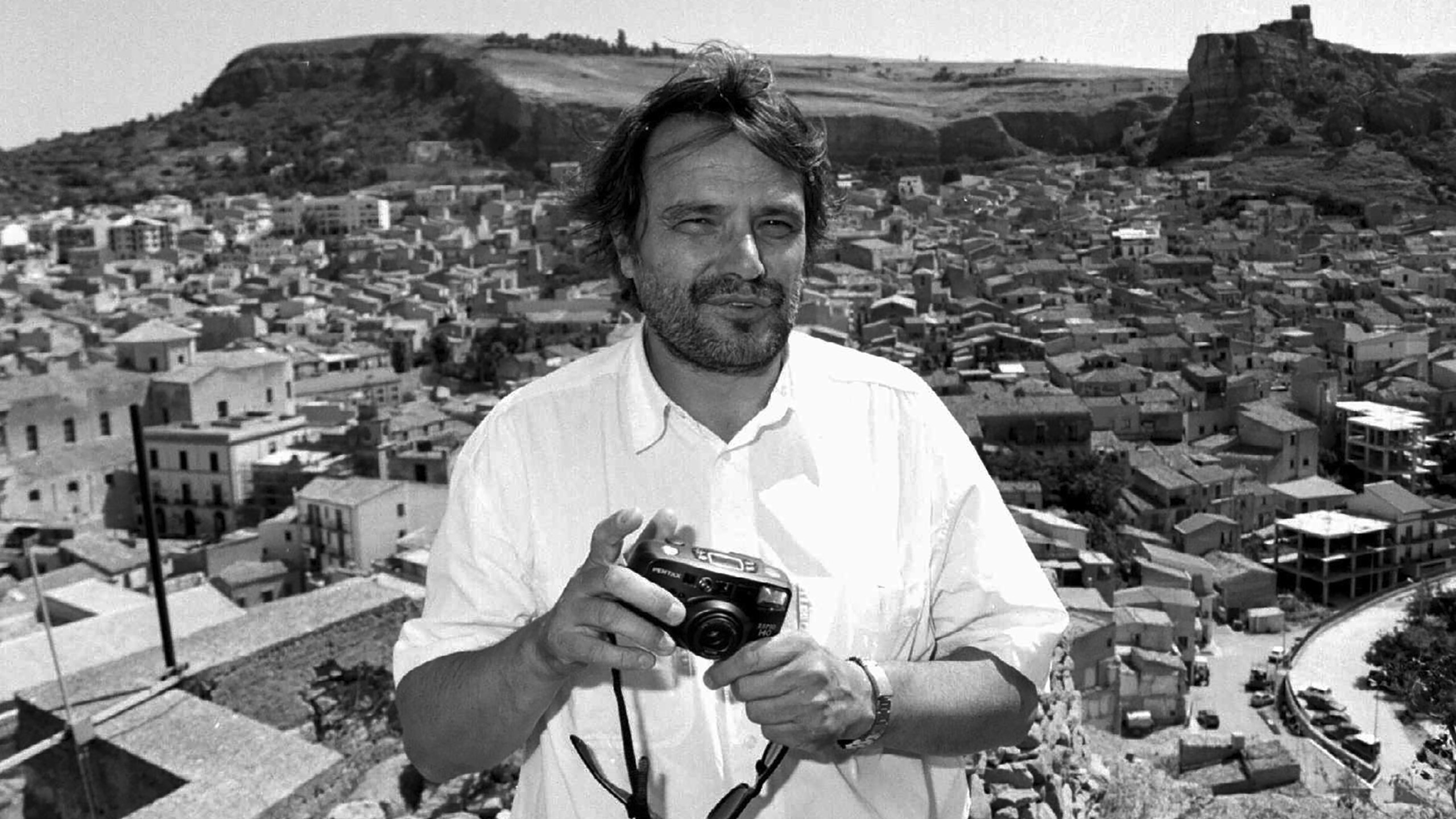 Italian photographer Oliviero Toscani holds his camera while in Corleone, Sicily island, southern Italy, on July 2, 1996. (AP Photo/Alessandro Fucarini, File)