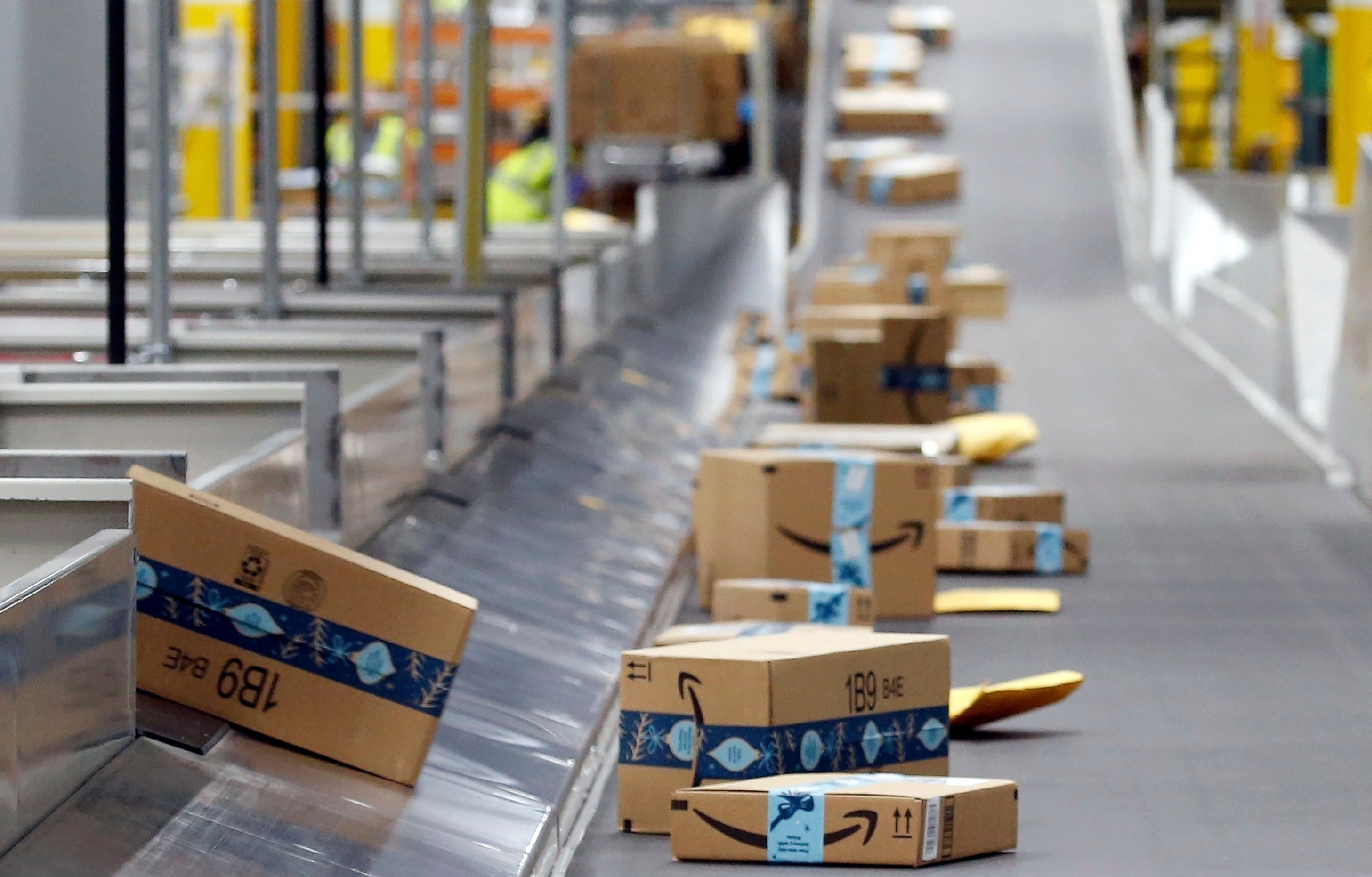 FILE - Amazon packages move along a conveyor at an Amazon warehouse facility, Dec. 17, 2019, in Goodyear, Ariz. (AP Photo/Ross D. Franklin, File)