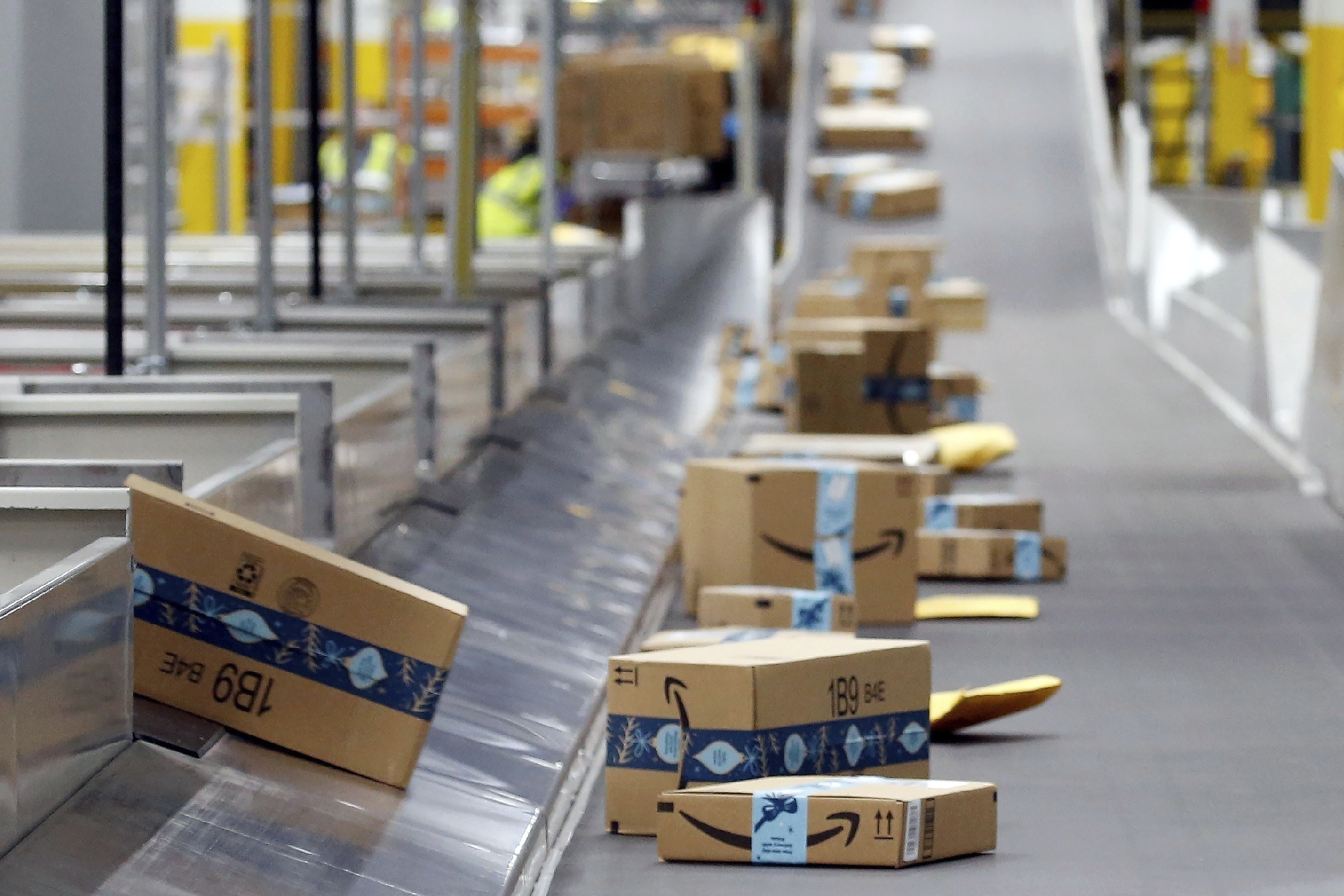 FILE - Amazon packages move along a conveyor at an Amazon warehouse facility, Dec. 17, 2019, in Goodyear, Ariz. (AP Photo/Ross D. Franklin, File)