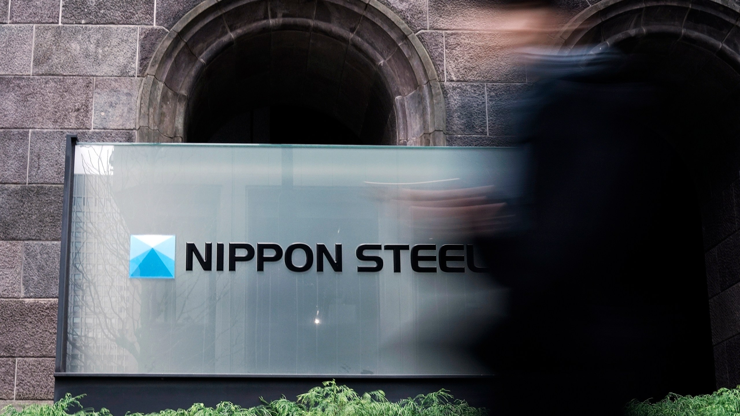 A person walks past a Nippon Steel Corporation sign at the company headquarters Tuesday, Jan. 7, 2025, in Tokyo. (AP Photo/Eugene Hoshiko)