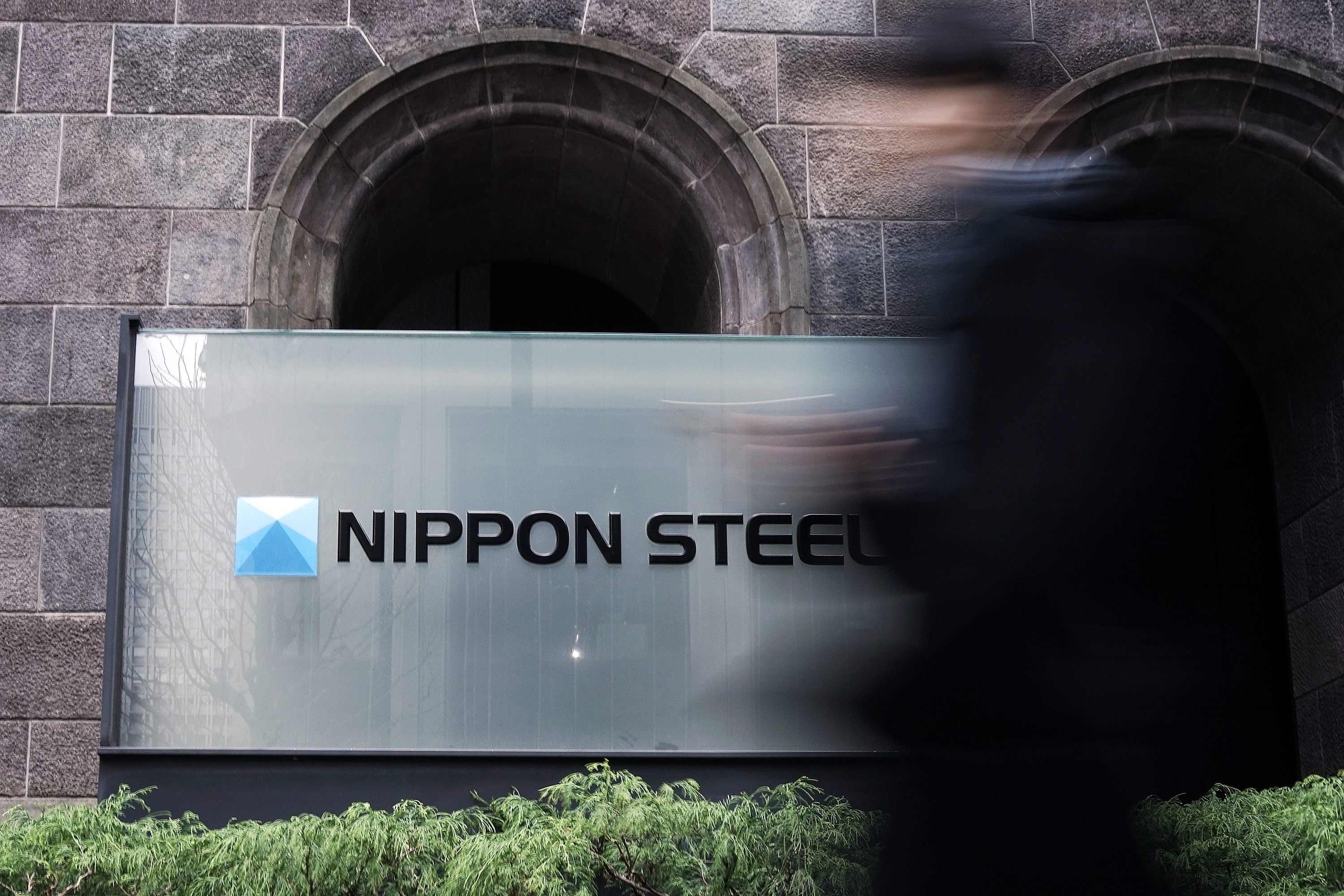 A person walks past a Nippon Steel Corporation sign at the company headquarters Tuesday, Jan. 7, 2025, in Tokyo. (AP Photo/Eugene Hoshiko)