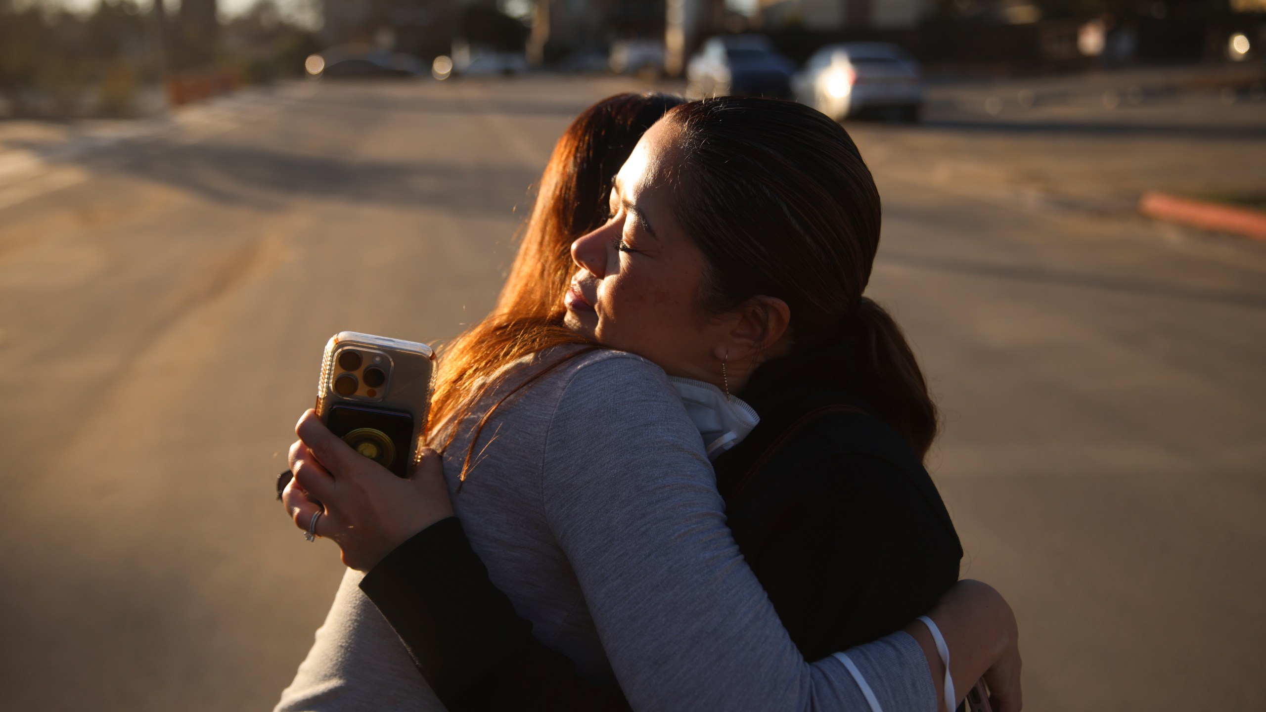 Pasadena Park Healthcare & Wellness Center COO Amy Johnson, left, hugs Rhea Bartolome, vice president of operations, outside their center after the Eaton Fire, Sunday, Jan. 12, 2025, in Pasadena, Calif. They returned to check on the facility after evacuating senior care residents from the fire. (AP Photo/Ethan Swope)