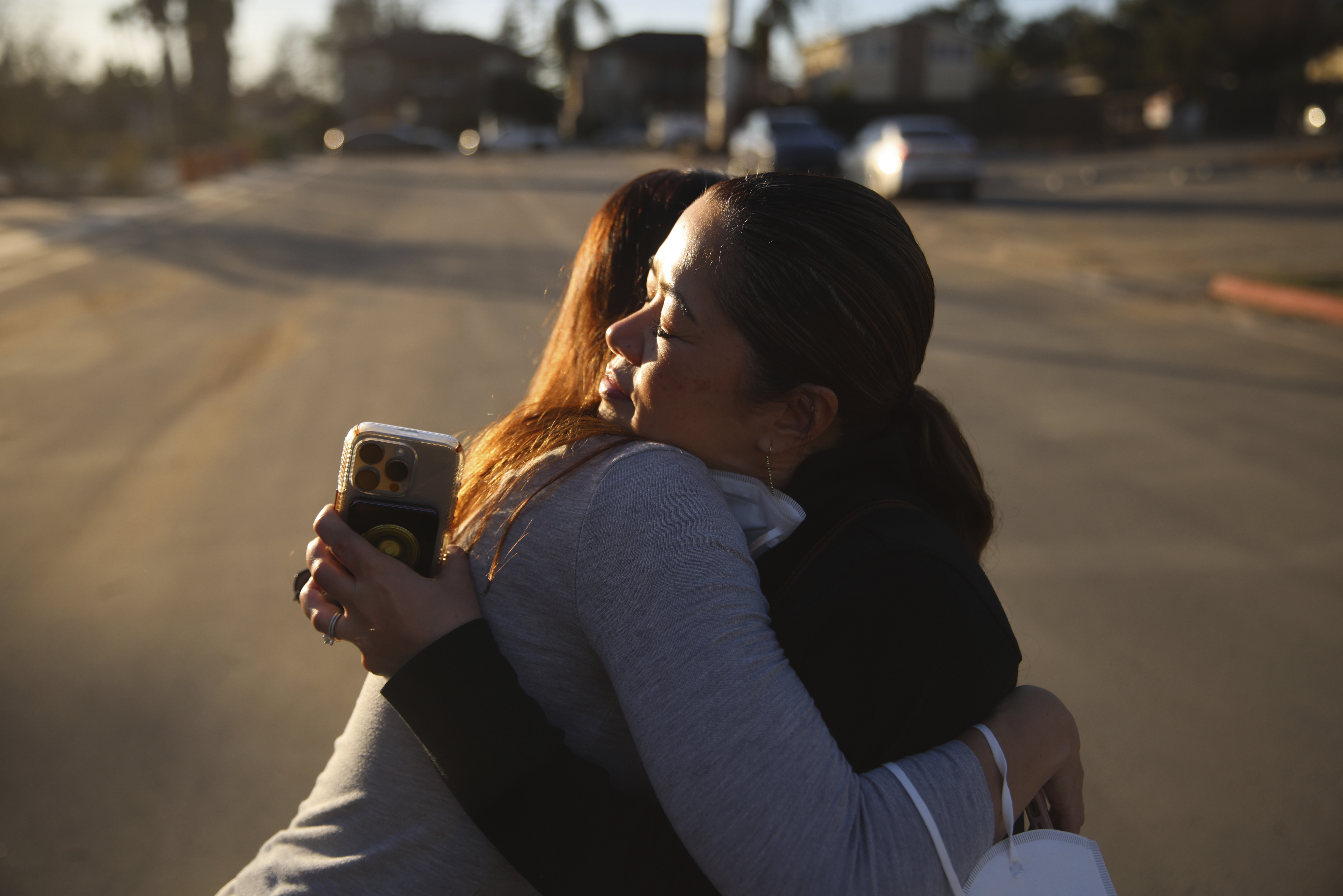 Pasadena Park Healthcare & Wellness Center COO Amy Johnson, left, hugs Rhea Bartolome, vice president of operations, outside their center after the Eaton Fire, Sunday, Jan. 12, 2025, in Pasadena, Calif. They returned to check on the facility after evacuating senior care residents from the fire. (AP Photo/Ethan Swope)