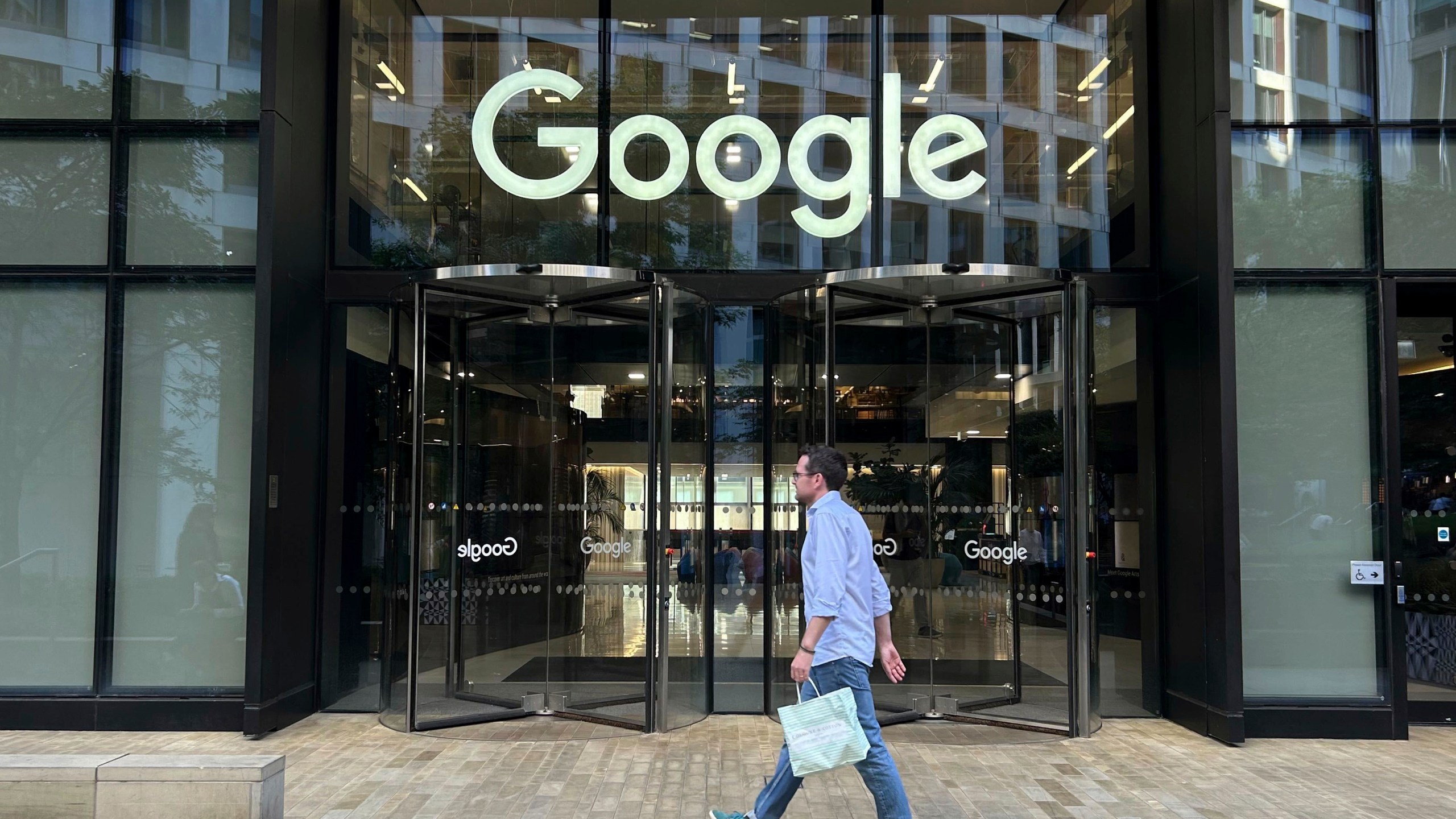 FILE - A man walks past Google's offices in London's Kings Cross area, on Aug. 10, 2024. (AP Photo/Brian Melley, File)