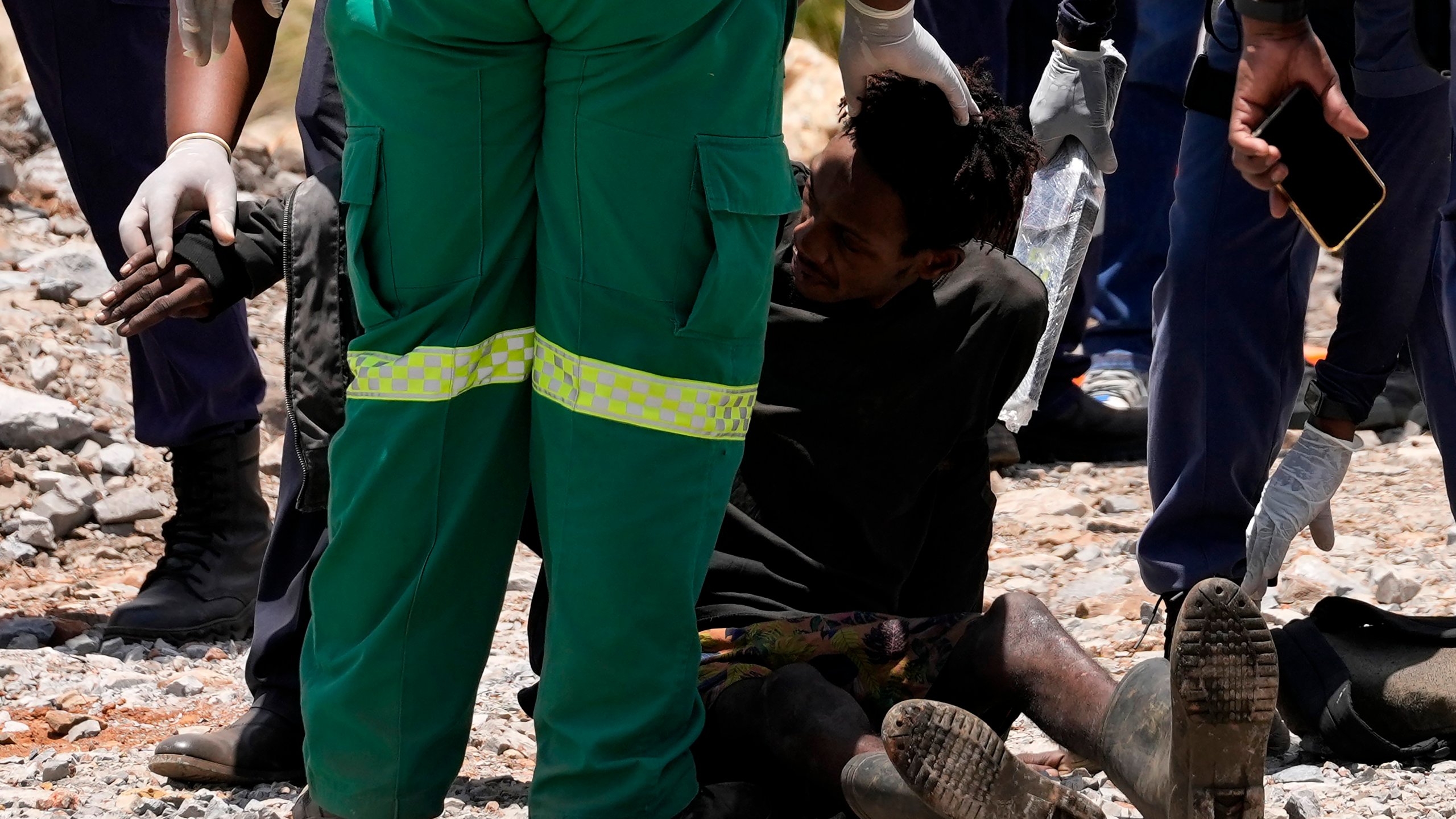 A miner is assisted by rescue workers after he was rescued from below ground in an abandoned gold mine in Stilfontein, South Africa, Tuesday, Jan. 14, 2025. (AP Photo/Themba Hadebe)