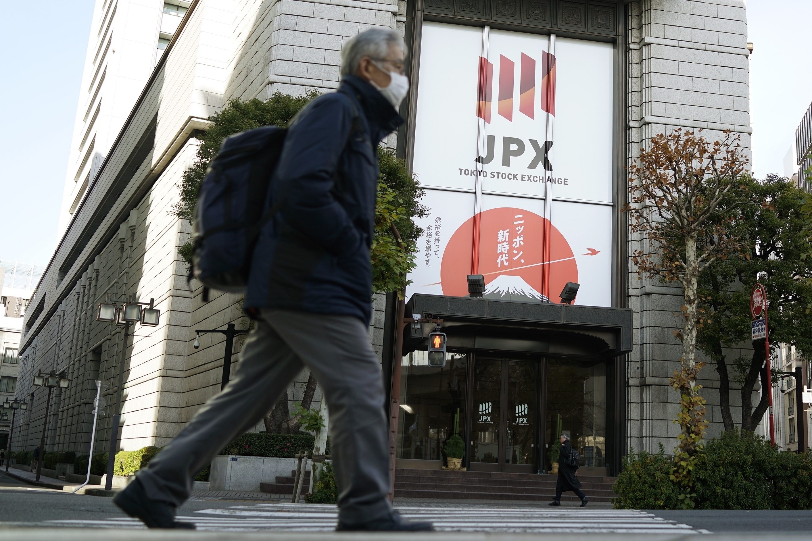 FILE - People walk in front of Tokyo Stock Exchange building in Tokyo, Dec. 25, 2024. (AP Photo/Eugene Hoshiko, File)