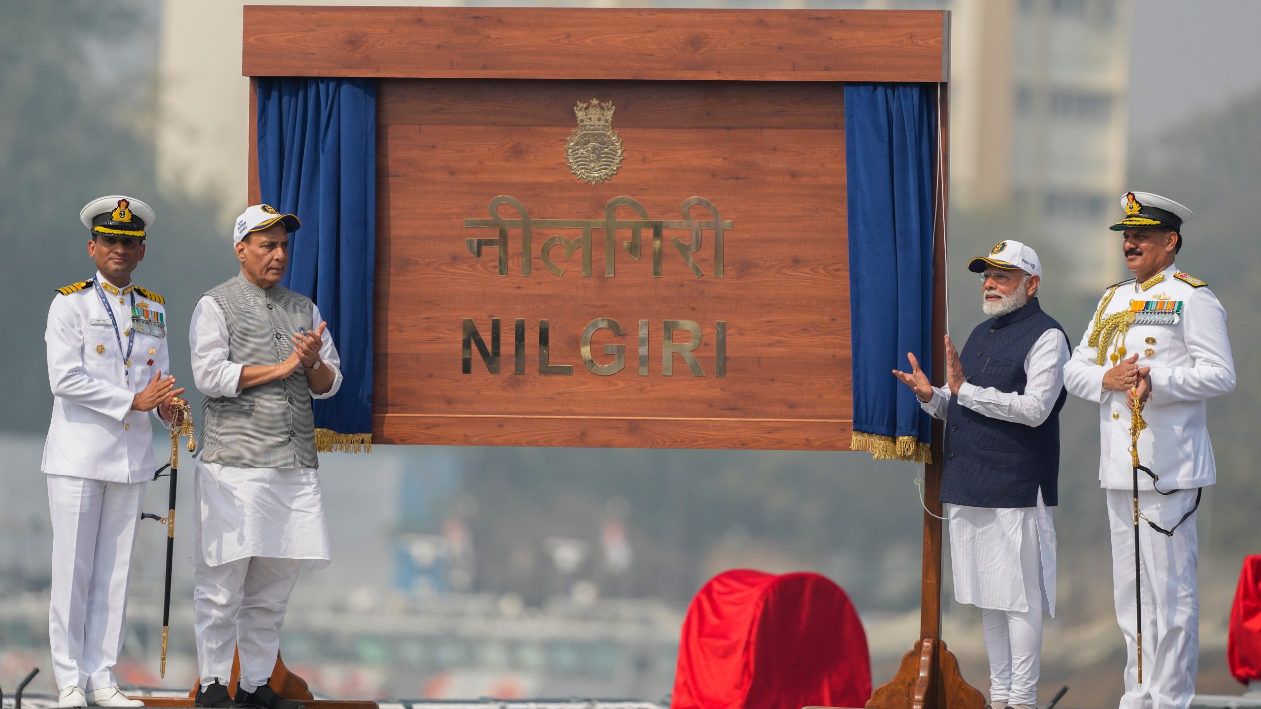 From right to left, India's Navy Chief Dinesh Kumar Tripathi, Indian Prime Minister Narendra Modi, and Indian Defense Minister Rajnath Singh, are seen on the deck of INS Nilgiri during its commissioning ceremony at a naval dockyard in Mumbai, India, Wednesday, Jan. 15, 2025. (AP Photo/Rafiq Maqbool)