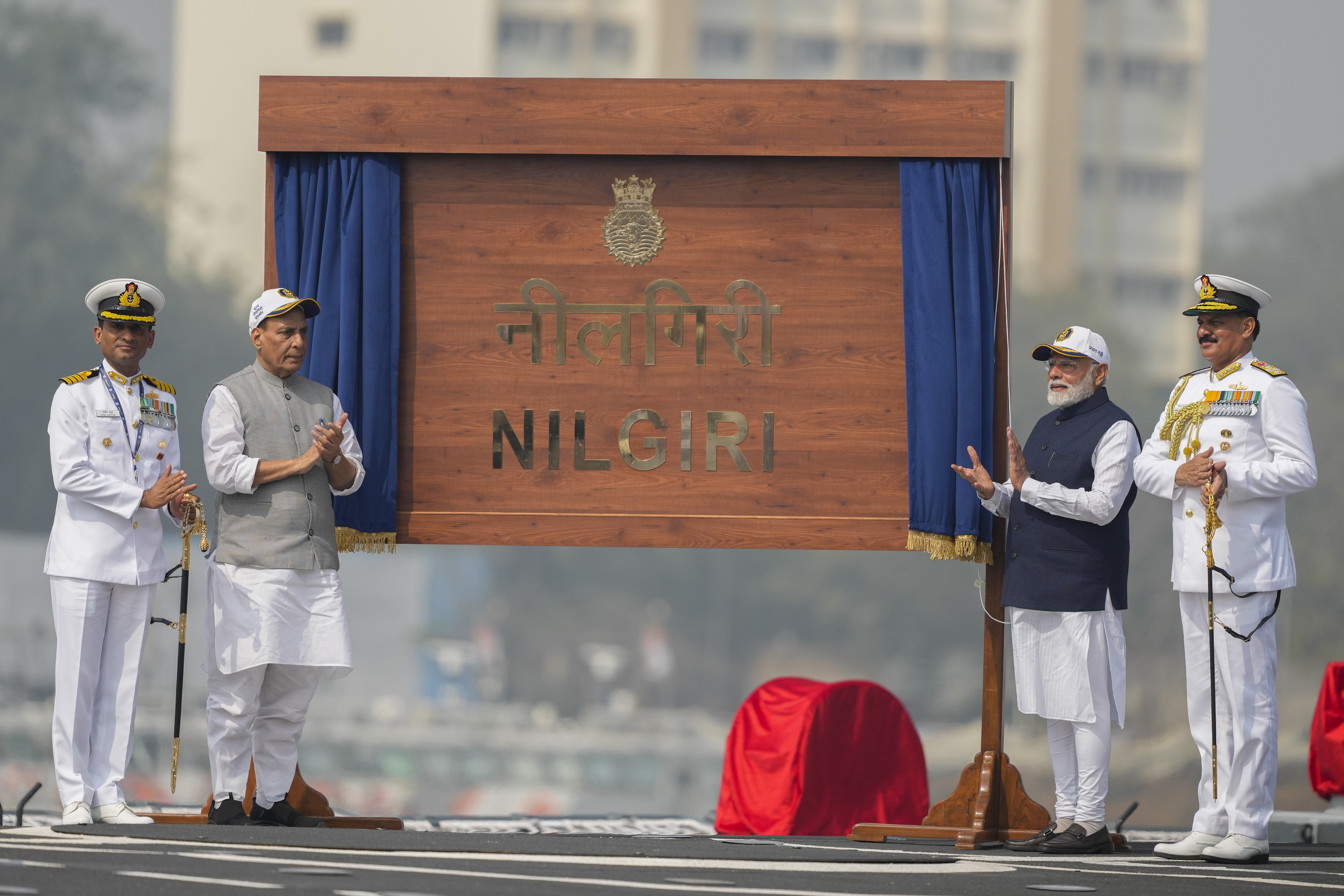 From right to left, India's Navy Chief Dinesh Kumar Tripathi, Indian Prime Minister Narendra Modi, and Indian Defense Minister Rajnath Singh, are seen on the deck of INS Nilgiri during its commissioning ceremony at a naval dockyard in Mumbai, India, Wednesday, Jan. 15, 2025. (AP Photo/Rafiq Maqbool)