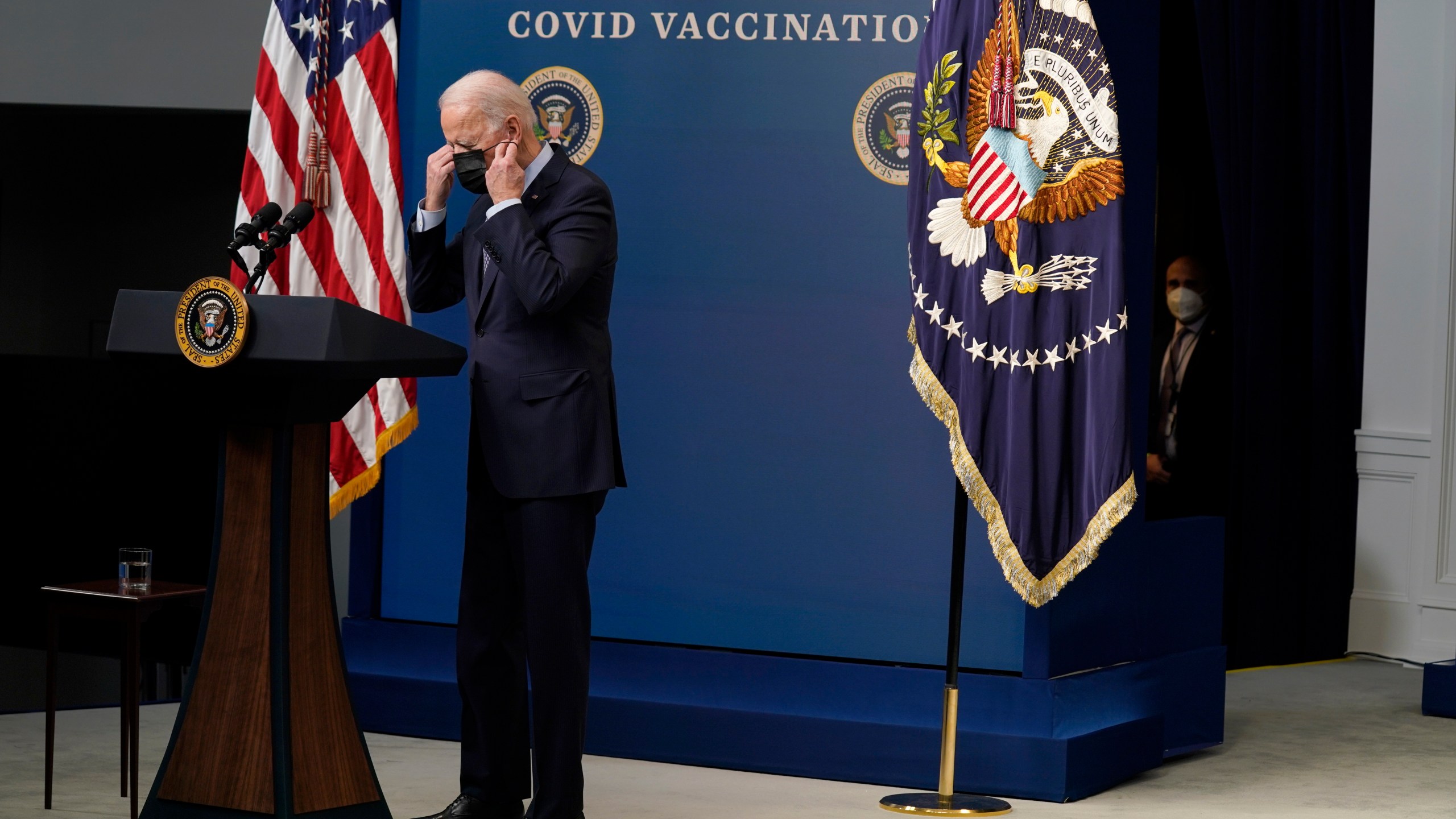 FILE - President Joe Biden puts on his face mask after speaking during an event to commemorate the 50 millionth COVID-19 shot, in the South Court Auditorium on the White House campus, Feb. 25, 2021, in Washington. (AP Photo/Evan Vucci, File)