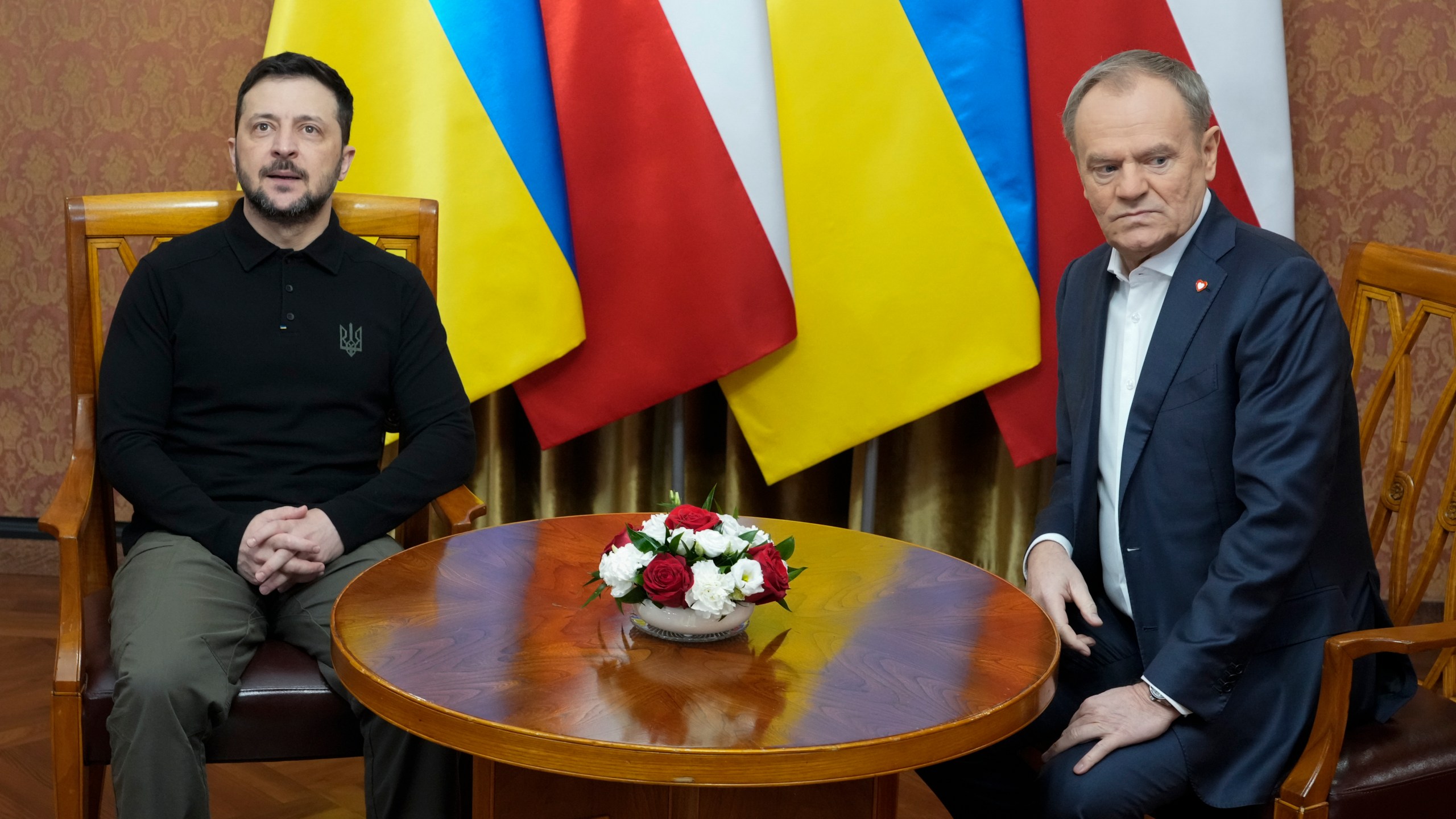 Polish Prime Minister Donald Tusk, right, speaks with Ukrainian President Volodymyr Zelenskyy after the two countries reached an agreement on a longstanding source of tensions between them: the exhumation of Polish victims of World War II-era massacres by Ukrainian nationalists, in Warsaw, Poland, on Wednesday, Jan. 15, 2025. (AP Photo/Czarek Sokolowski)