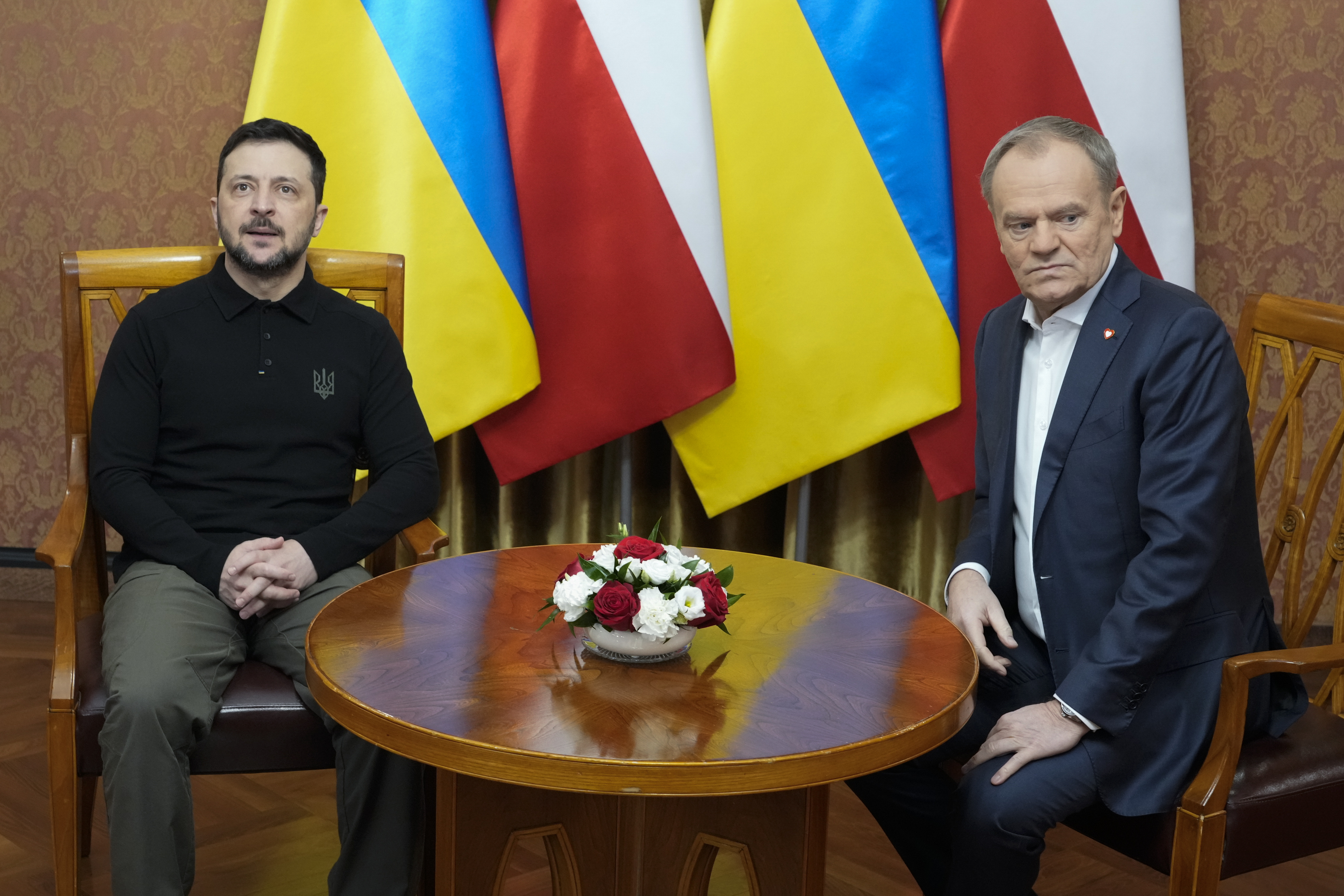 Polish Prime Minister Donald Tusk, right, speaks with Ukrainian President Volodymyr Zelenskyy after the two countries reached an agreement on a longstanding source of tensions between them: the exhumation of Polish victims of World War II-era massacres by Ukrainian nationalists, in Warsaw, Poland, on Wednesday, Jan. 15, 2025. (AP Photo/Czarek Sokolowski)