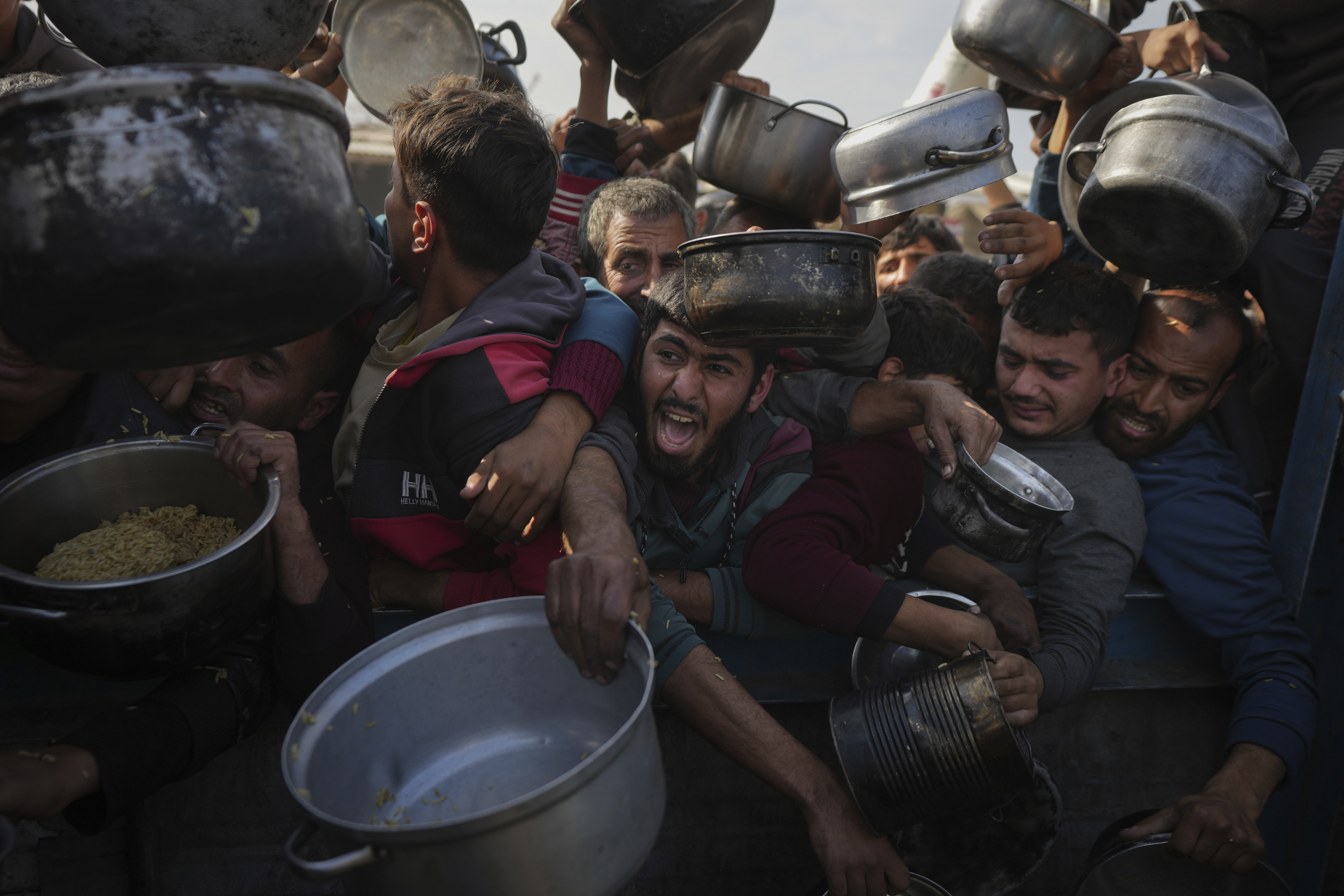 FILE - Palestinians struggle for food at a distribution center in Khan Younis, Gaza Strip, Jan. 9, 2025. (AP Photo/Abdel Kareem Hana, File)