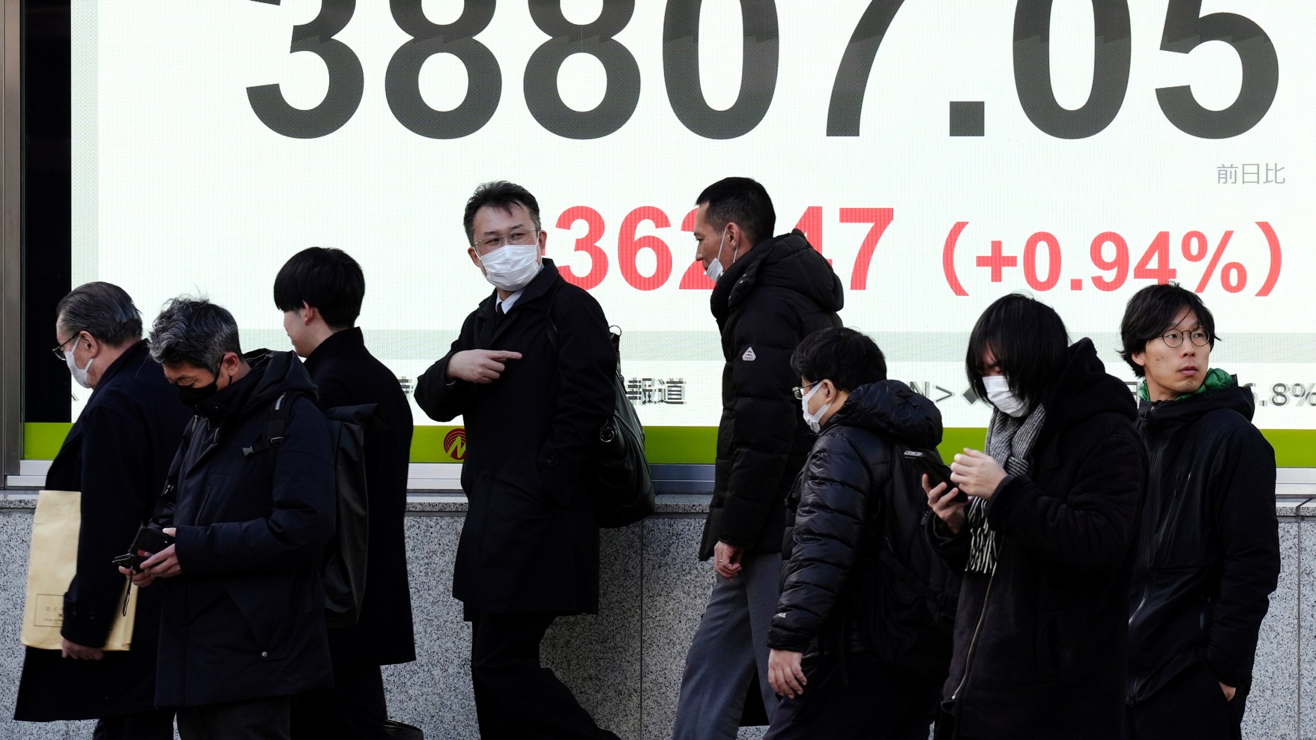 People walk in front of an electronic stock board showing Japan's Nikkei index at a securities firm Thursday, Jan. 16, 2025, in Tokyo. (AP Photo/Eugene Hoshiko)