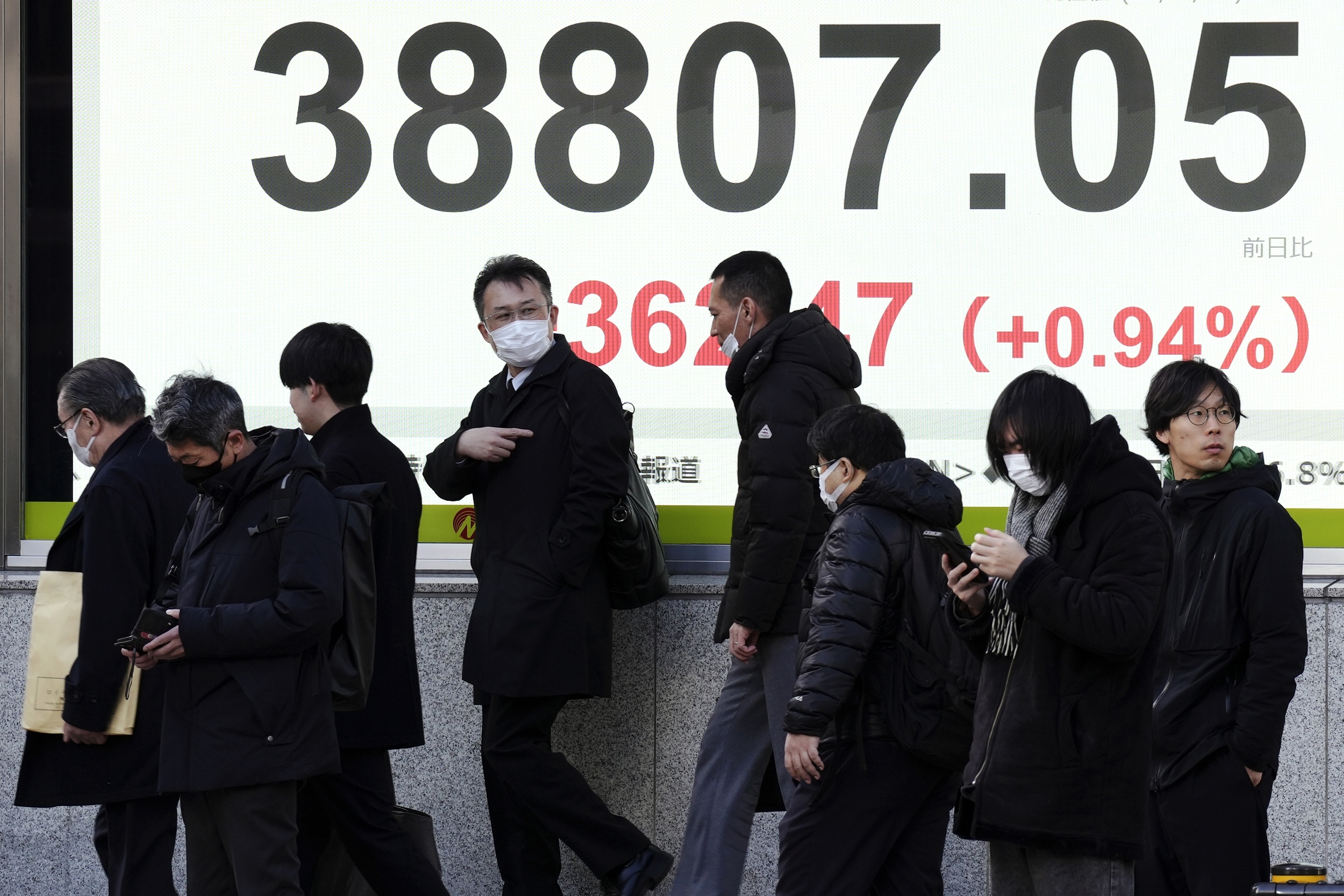 People walk in front of an electronic stock board showing Japan's Nikkei index at a securities firm Thursday, Jan. 16, 2025, in Tokyo. (AP Photo/Eugene Hoshiko)