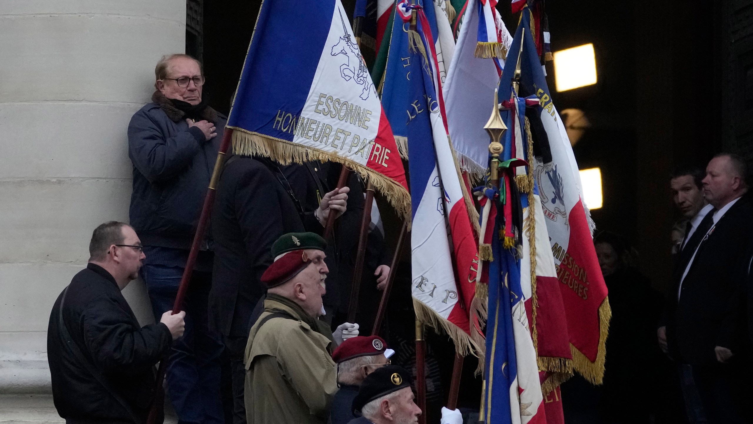 Veterans hold flags at the entrance of Notre Dame du Val-de-Grace church during a public memorial for late far-right leader Jean-Marie Le Pen, Thursday, Jan. 16, 2025 in Paris. Jean-Marie Le Pen, the founder of France's main far-right party, died on Jan.7, 2025 aged 96. (AP Photo/Michel Euler)