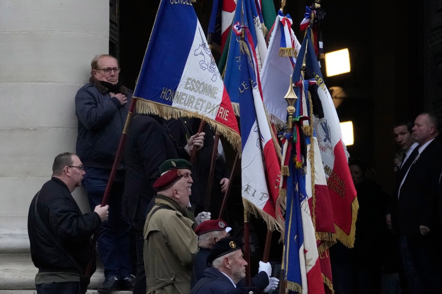 Veterans hold flags at the entrance of Notre Dame du Val-de-Grace church during a public memorial for late far-right leader Jean-Marie Le Pen, Thursday, Jan. 16, 2025 in Paris. Jean-Marie Le Pen, the founder of France's main far-right party, died on Jan.7, 2025 aged 96. (AP Photo/Michel Euler)