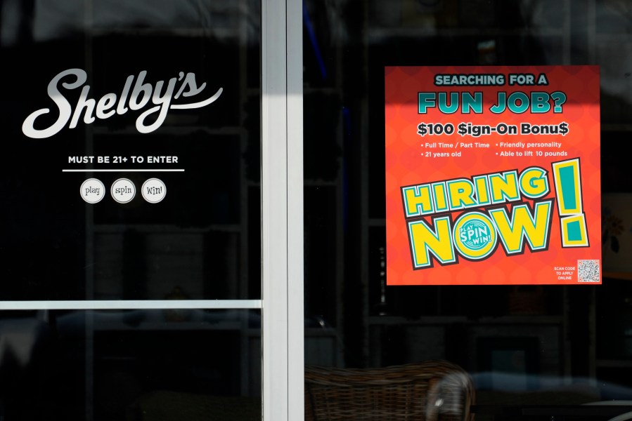 A hiring sign is displayed at a cafe in Streamwood, Ill., Tuesday, Dec. 3, 2024. (AP Photo/Nam Y. Huh)