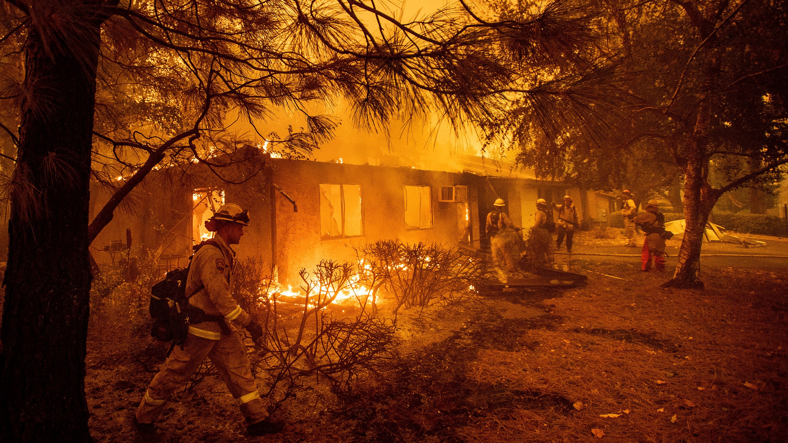 FILE - Firefighters work to keep flames from spreading through the Shadowbrook apartment complex as a wildfire burns through Paradise, Calif., on Nov. 9, 2018. (AP Photo/Noah Berger, File)