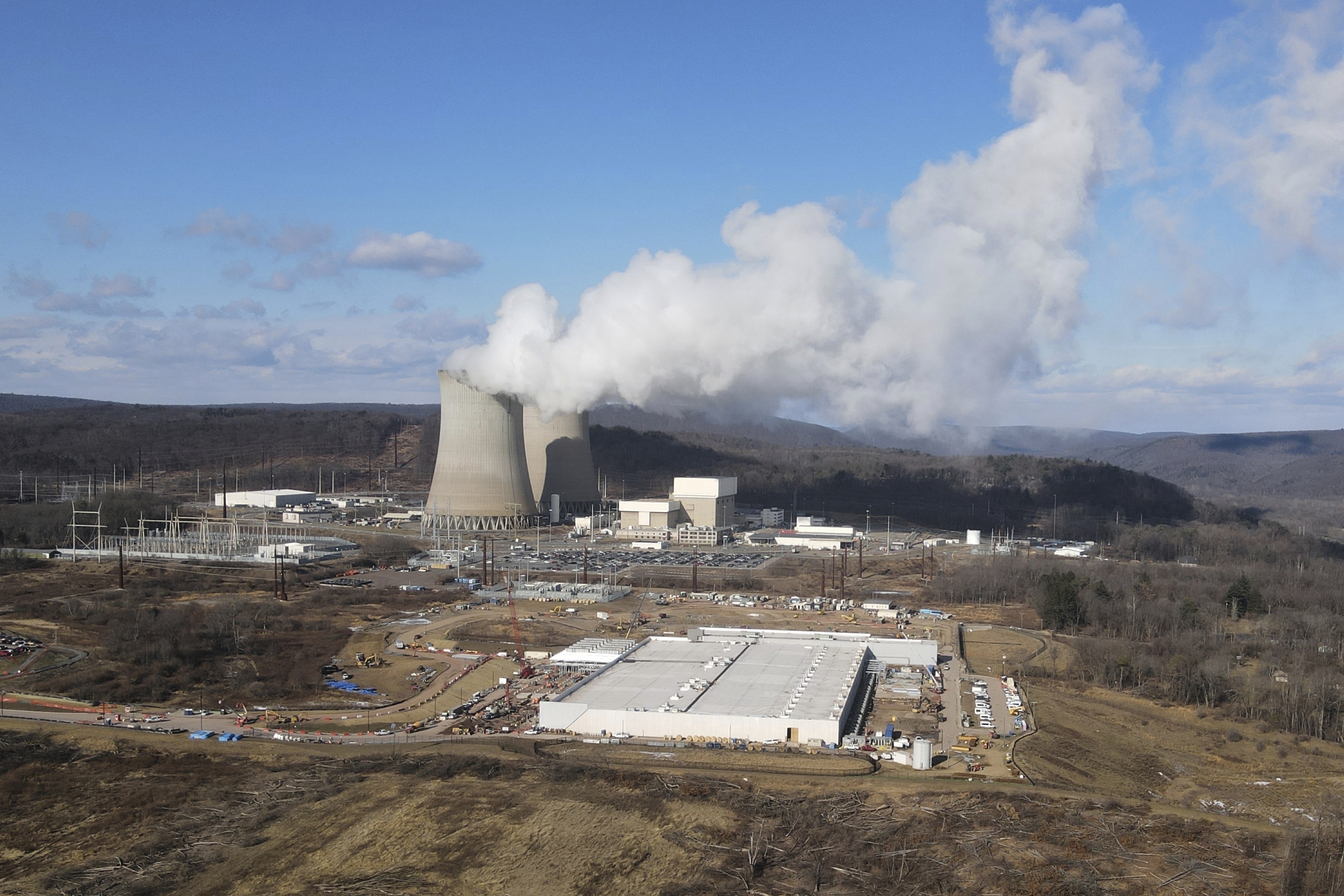 A data center owned by Amazon Web Services, front right, is under construction next to the Susquehanna nuclear power plant in Berwick, Pa., on Tuesday, Jan. 14, 2024. (AP Photo/Ted Shaffrey)