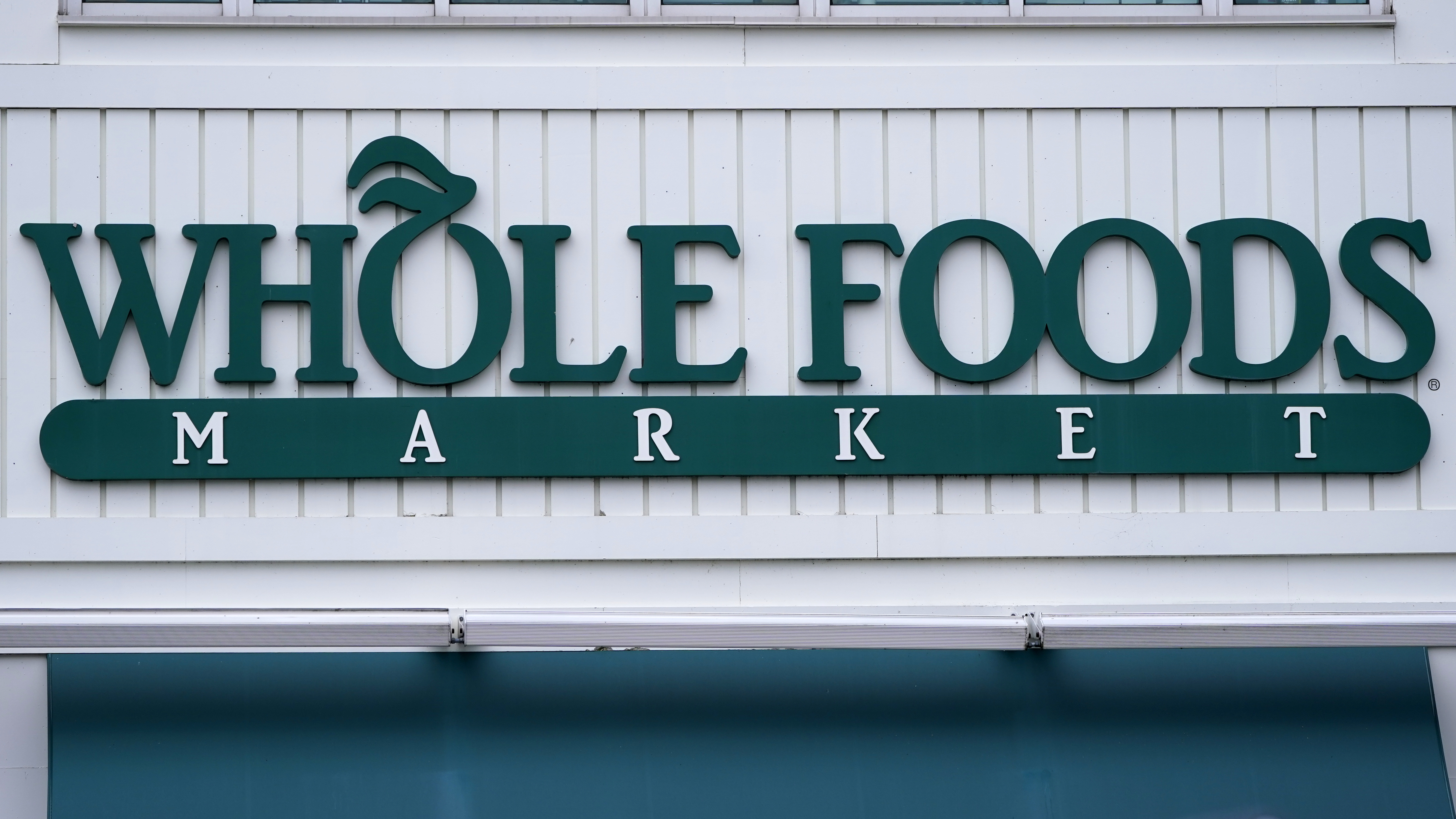 FILE - The Whole Foods Market logo is shown on the front of a store, July 14, 2021, in Cambridge, Mass. (AP Photo/Charles Krupa, File)