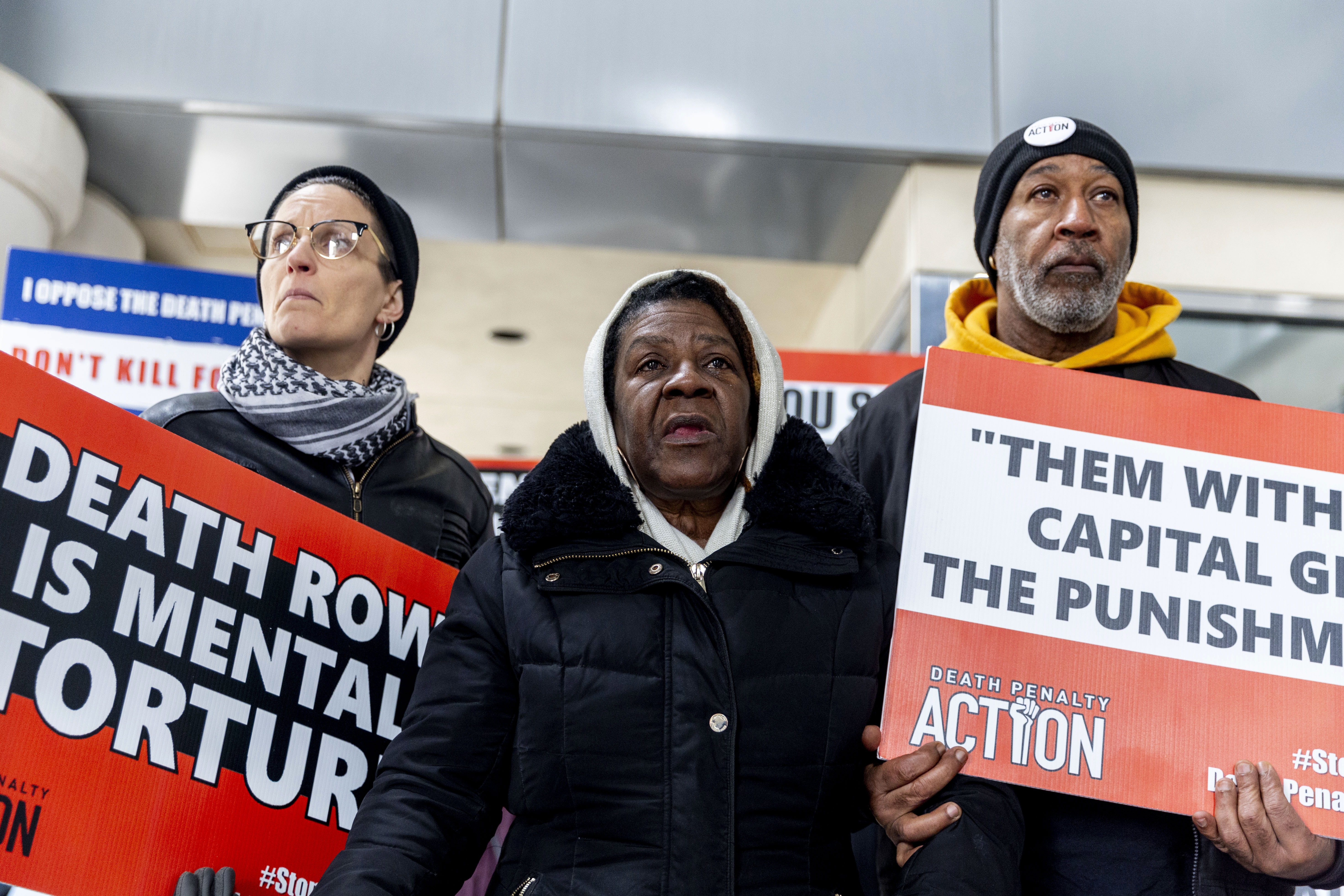 Lizz Schallert, left, and Charles Keith, right, stand in solidarity with Carol Frazier, mother of Demetrius Frazier, as she pleads publicly Tuesday, Jan. 28, 2025, in Lansing, Mich., to Gov. Gretchen Whitmer to bring home her son Demetrius, a Detroit man convicted of rape and a separate murder of a 14-year-old in the early 1990s, who was serving a life sentence when he was charged with another murder in Alabama and is scheduled to be executed there Feb. 6. (Jake May/MLive.com/The Flint Journal via AP)