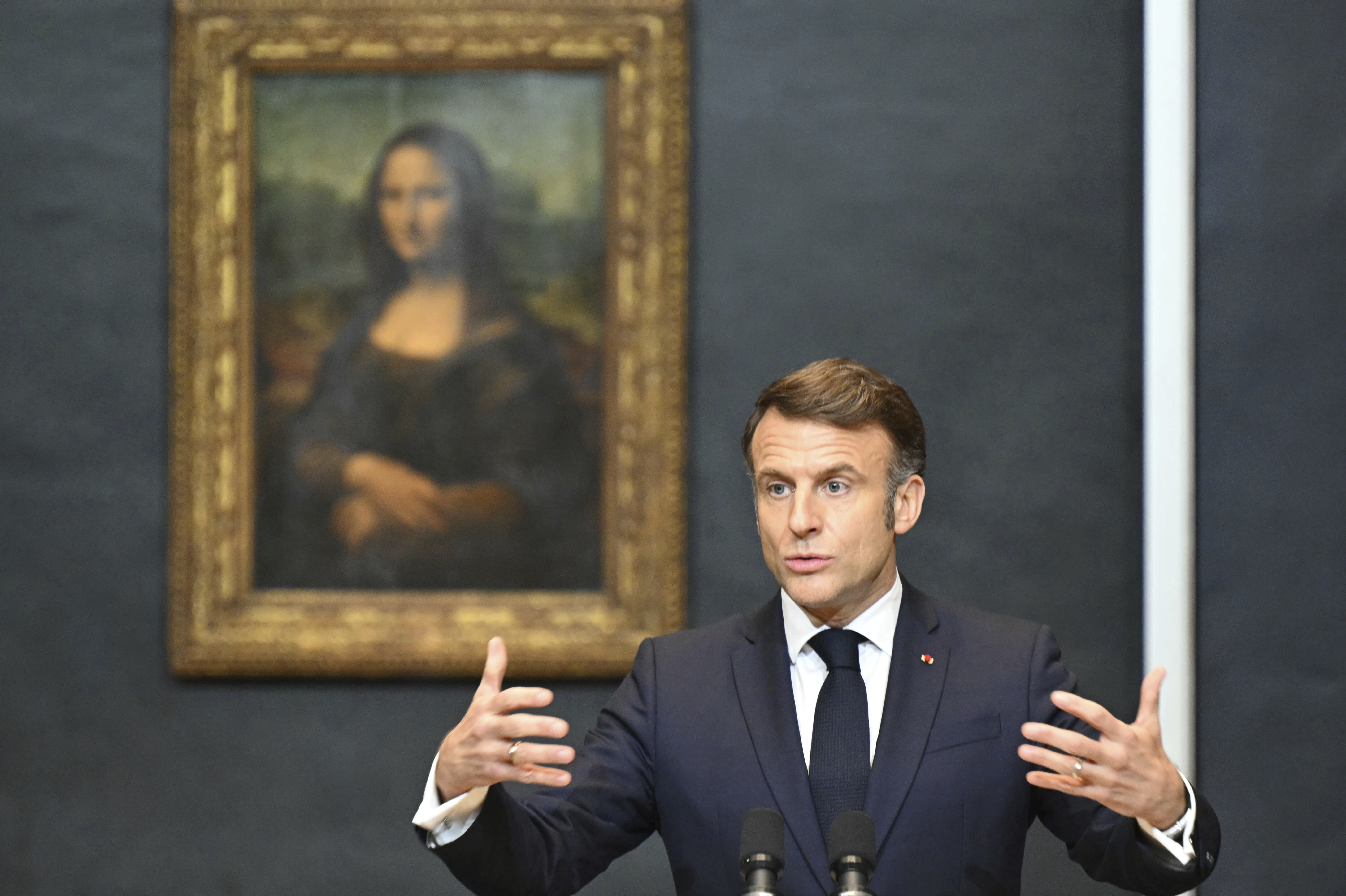 French President Emmanuel Macron gives a speech to announce a multi-year overhaul, long-term investments to modernize the Louvre museum, next to Leonardo da Vinci's painting of the Mona Lisa, at the Louvre Museum, Tuesday, Jan. 28, 2025 in Paris. ( Bertrand Guay, Pool via AP)