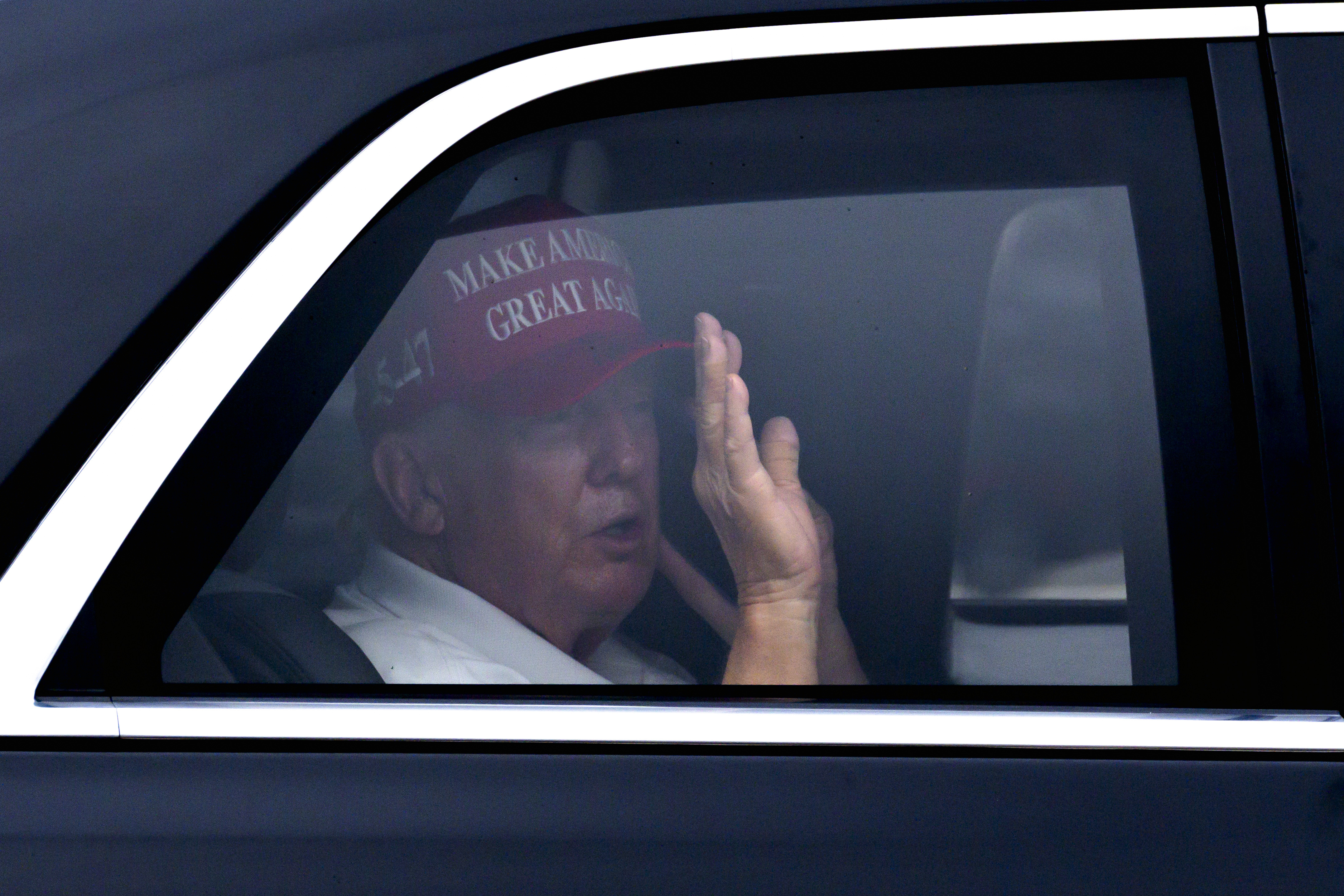 President Donald Trump waves from his vehicle as he arrives at the Trump International Golf Club, Monday, Feb. 17, 2025, in West Palm Beach, Fla. (AP Photo/Ben Curtis)